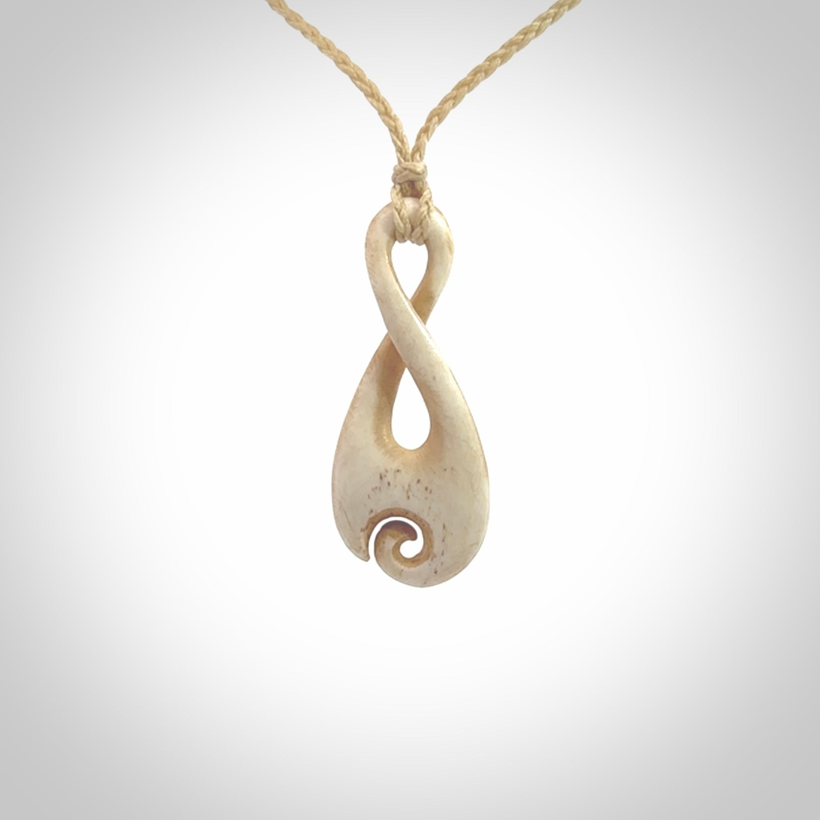 Hand carved Single twist pendant with a little koru carved into the bottom. This pendant is carved from a lovely cream coloured bone. The artist is Yuri Terenyi. Bone art to wear by NZ Pacific.