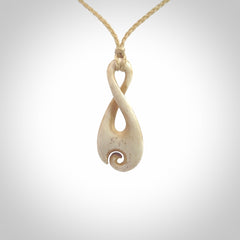 Hand carved Single twist pendant with a little koru carved into the bottom. This pendant is carved from a lovely cream coloured bone. The artist is Yuri Terenyi. Bone art to wear by NZ Pacific.