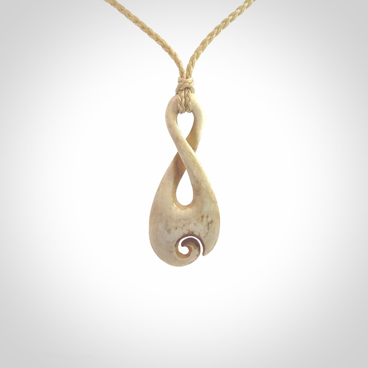 Hand carved Single twist pendant with a little koru carved into the bottom. This pendant is carved from a lovely cream coloured bone. The artist is Yuri Terenyi. Bone art to wear by NZ Pacific.