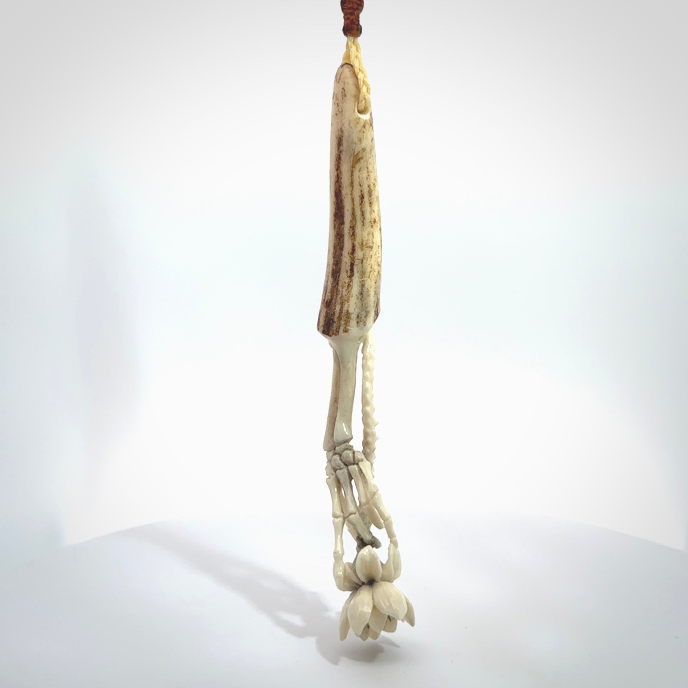 Hand carved deer antler, bone skeleton hand holding a flower pendant online for sale. Creative necklace for lovers of skeletons hand made from deer antler, bone. Free shipping worldwide. We provide this pendant with an adjustable cord.