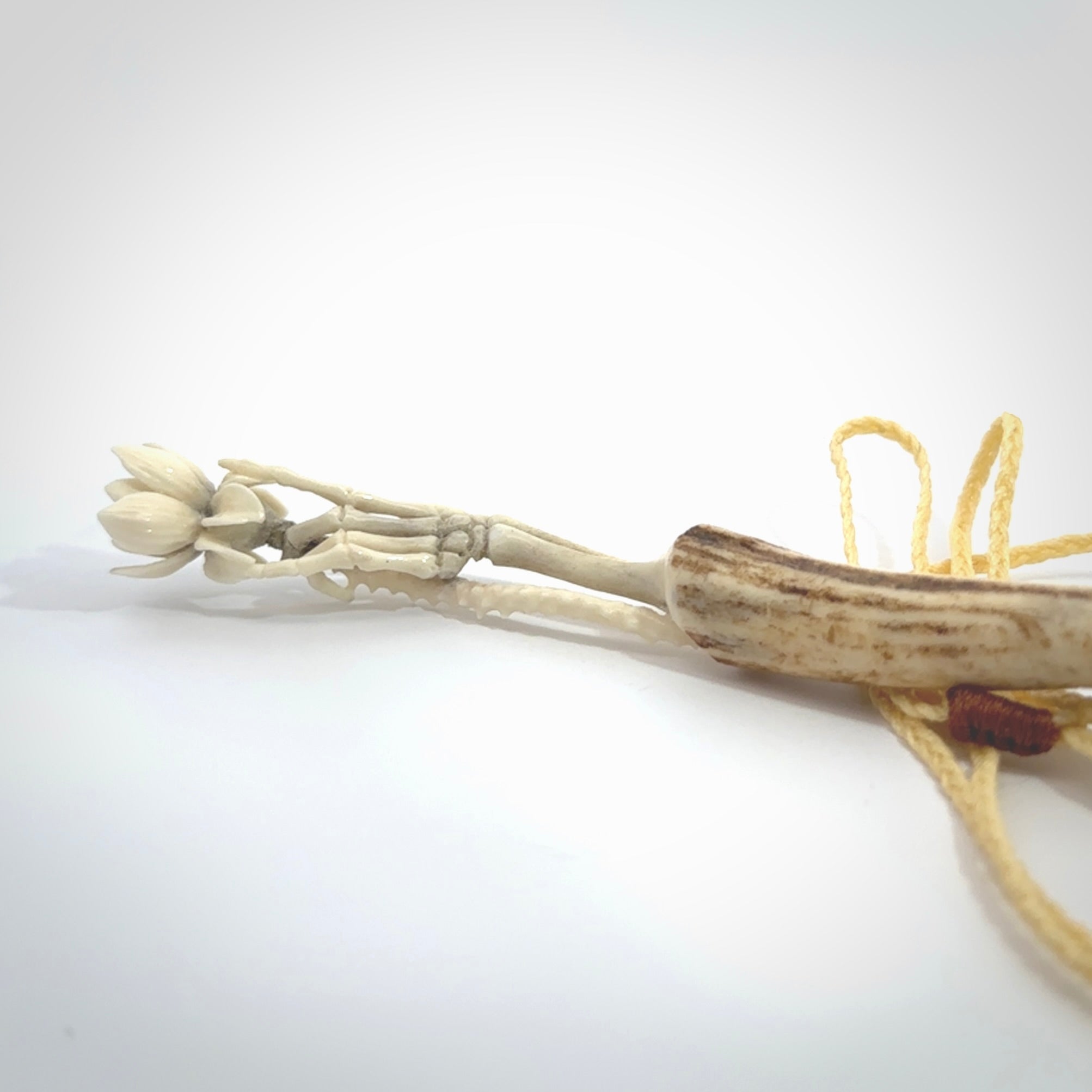 Hand carved deer antler, bone skeleton hand holding a flower pendant online for sale. Creative necklace for lovers of skeletons hand made from deer antler, bone. Free shipping worldwide. We provide this pendant with an adjustable cord.