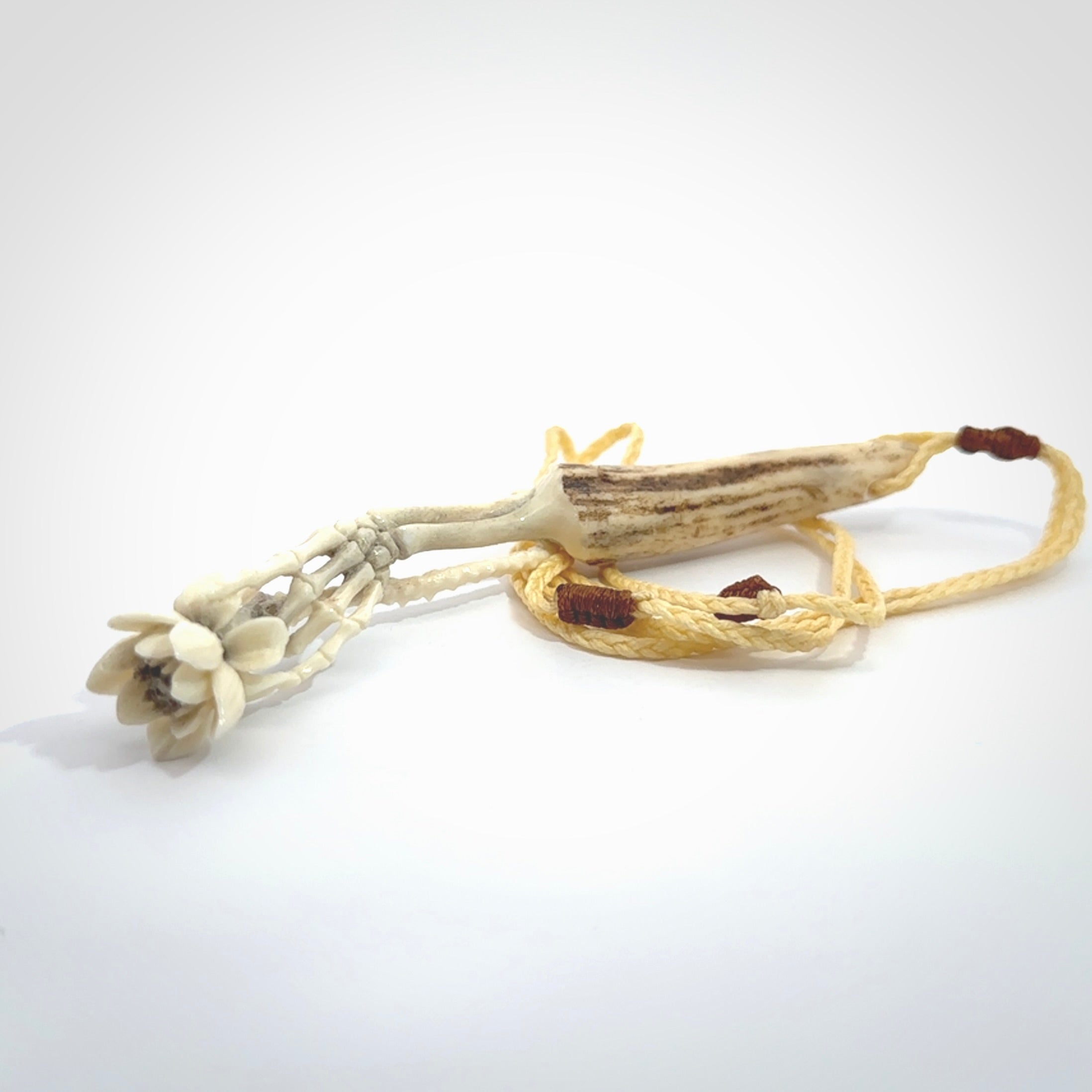 Hand carved deer antler, bone skeleton hand holding a flower pendant online for sale. Creative necklace for lovers of skeletons hand made from deer antler, bone. Free shipping worldwide. We provide this pendant with an adjustable cord.