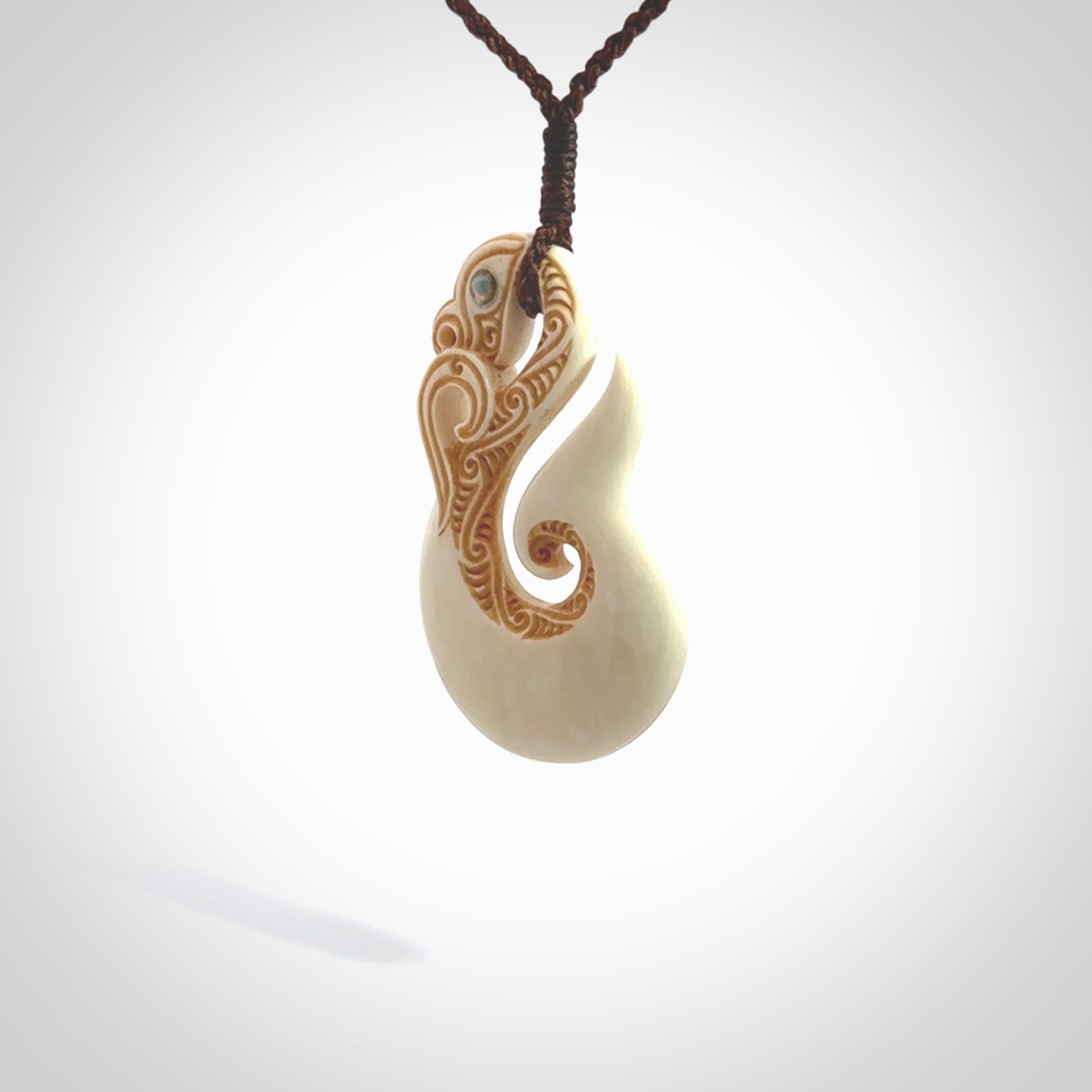 This is a wonderful, finely carved Manaia with hook and whale tail pendant. It is hand carved by Andrew Doughty and we will ship it to you free anywhere in the world. Hand made from bone and delivered to you with an adjustable brown cord. Packaged in a woven kete pouch.