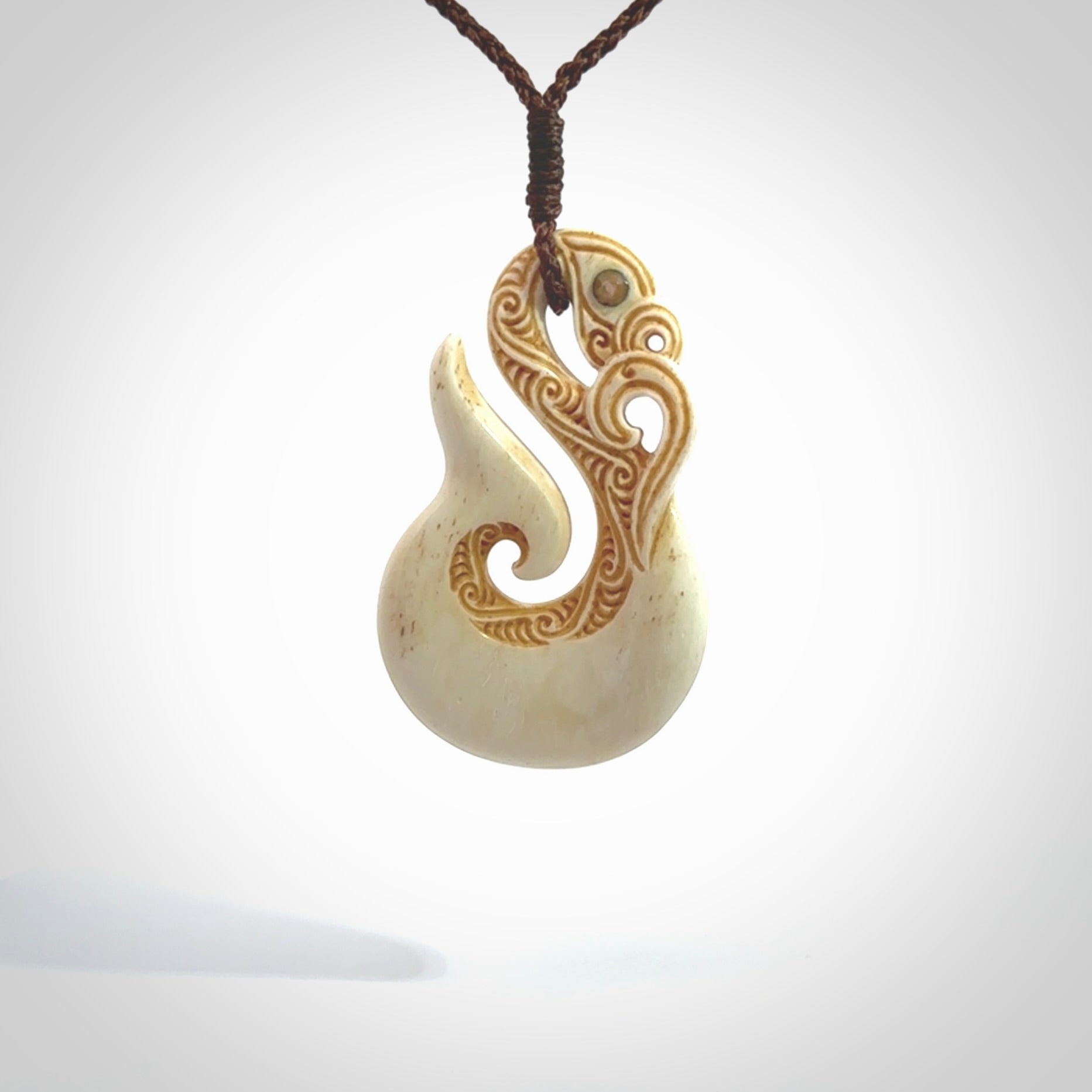 This is a wonderful, finely carved Manaia with hook and whale tail pendant. It is hand carved by Andrew Doughty and we will ship it to you free anywhere in the world. Hand made from bone and delivered to you with an adjustable brown cord. Packaged in a woven kete pouch.