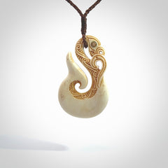 This is a wonderful, finely carved Manaia with hook and whale tail pendant. It is hand carved by Andrew Doughty and we will ship it to you free anywhere in the world. Hand made from bone and delivered to you with an adjustable brown cord. Packaged in a woven kete pouch.