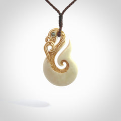 This is a wonderful, finely carved Manaia with hook and whale tail pendant. It is hand carved by Andrew Doughty and we will ship it to you free anywhere in the world. Hand made from bone and delivered to you with an adjustable brown cord. Packaged in a woven kete pouch.