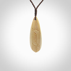 This is a wonderful, finely carved drop pendant. It is hand carved by Andrew Doughty and we will ship it to you free anywhere in the world. Hand made from bone with Paua shell and copper inlay. Delivered with an adjustable brown cord.