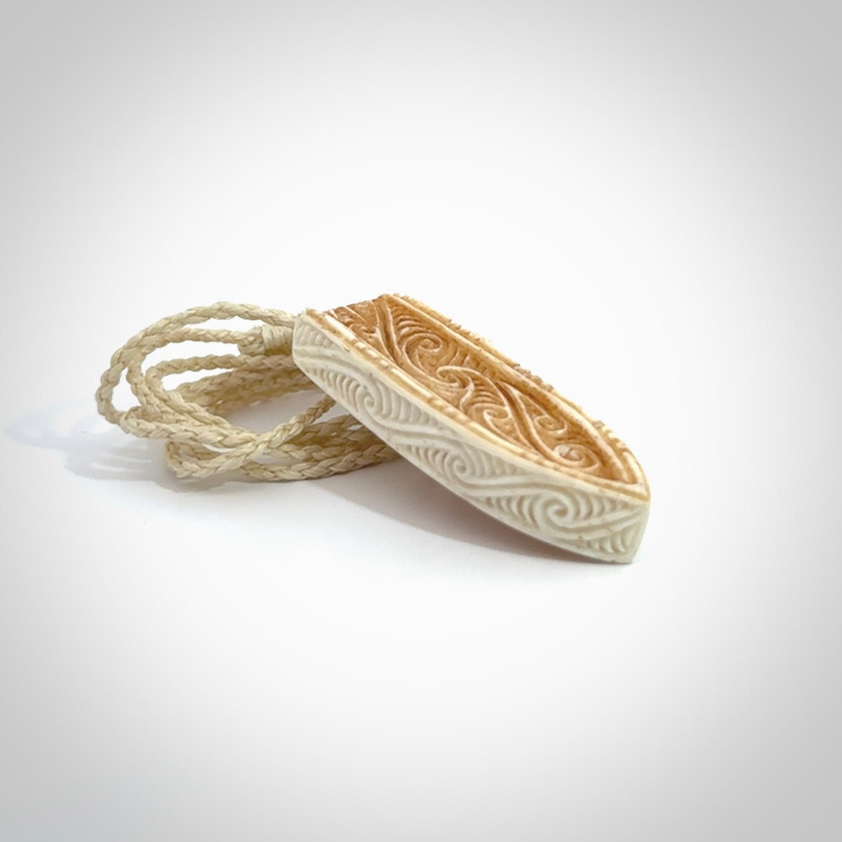 This is a wonderful, finely carved drop pendant. It is hand carved by Andrew Doughty and we will ship it to you free anywhere in the world. Hand made from bone and delivered to you with an adjustable ice white cord.