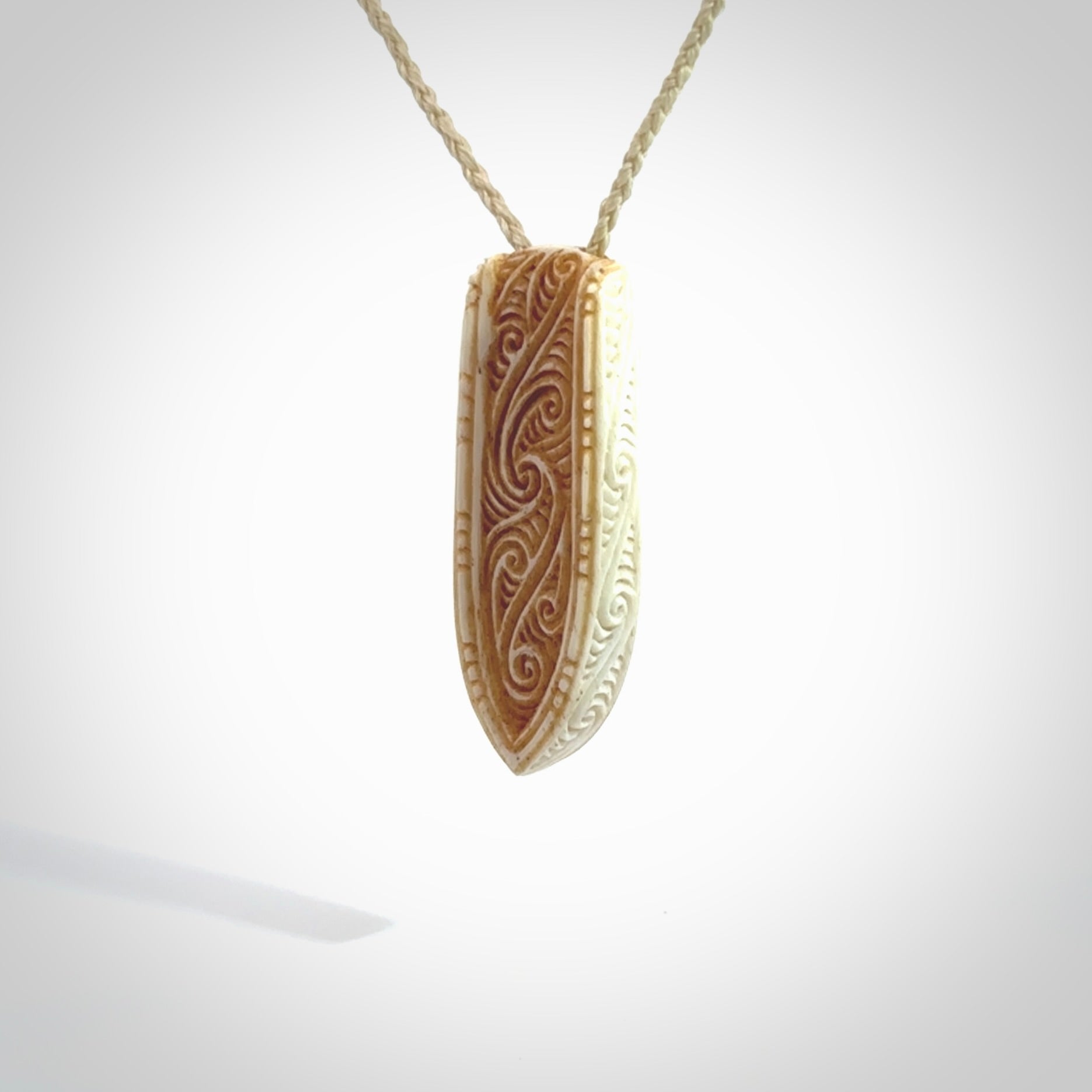 This is a wonderful, finely carved drop pendant. It is hand carved by Andrew Doughty and we will ship it to you free anywhere in the world. Hand made from bone and delivered to you with an adjustable ice white cord.