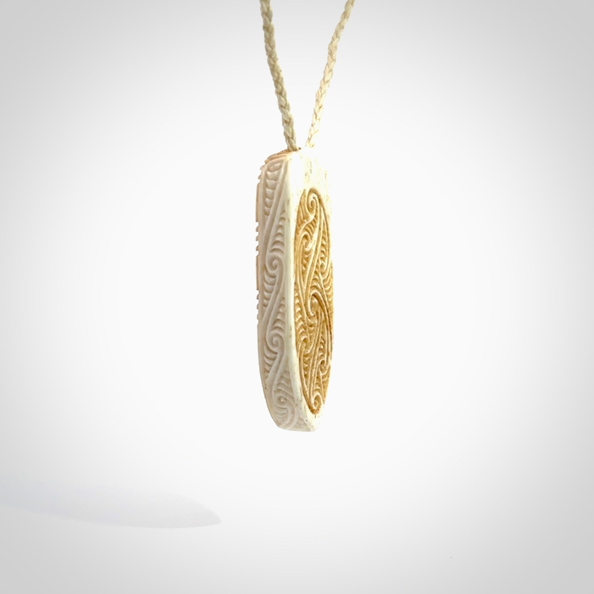 This is a wonderful, finely carved drop pendant. It is hand carved by Andrew Doughty and we will ship it to you free anywhere in the world. Hand made from bone and delivered to you with an adjustable ice white cord.