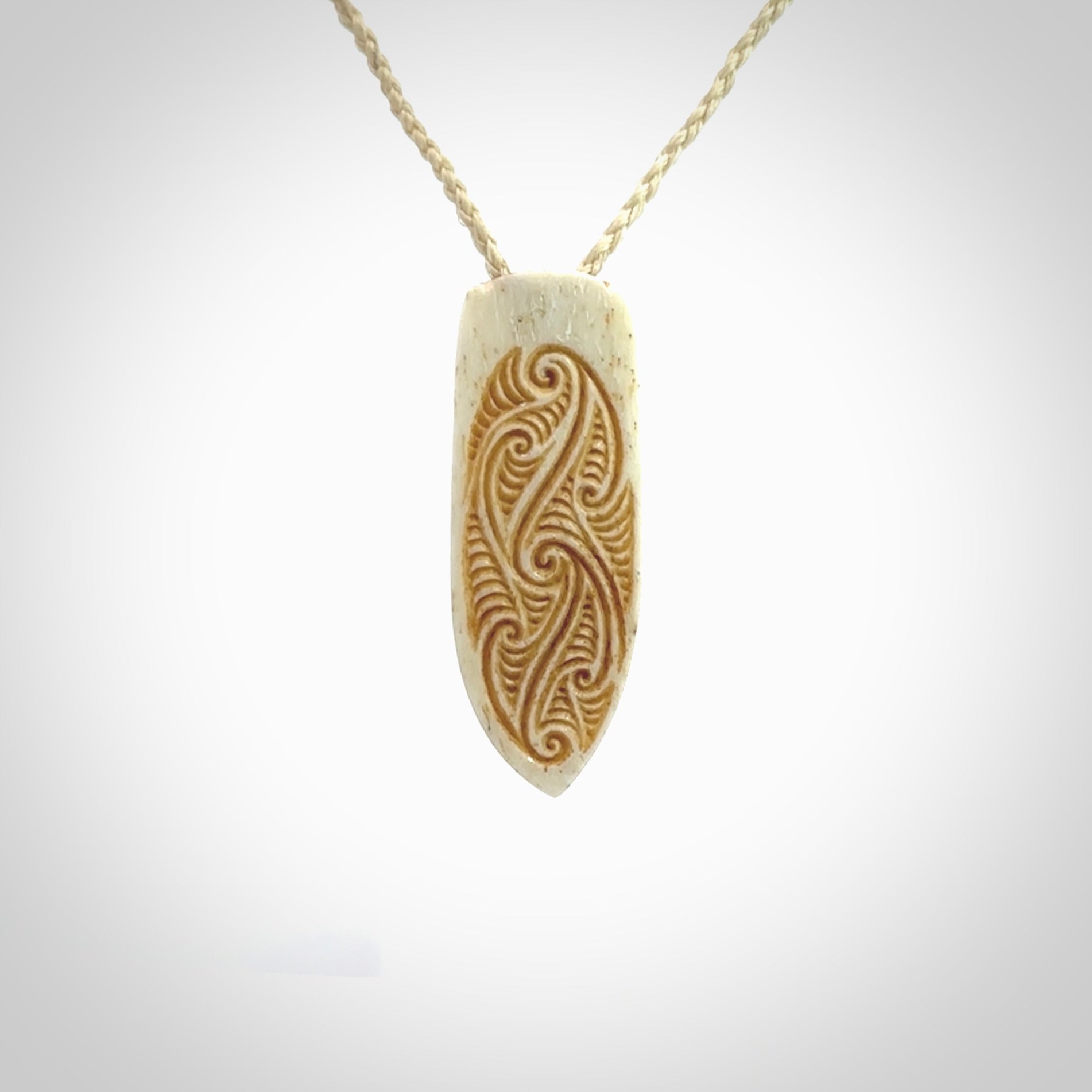 This is a wonderful, finely carved drop pendant. It is hand carved by Andrew Doughty and we will ship it to you free anywhere in the world. Hand made from bone and delivered to you with an adjustable ice white cord.