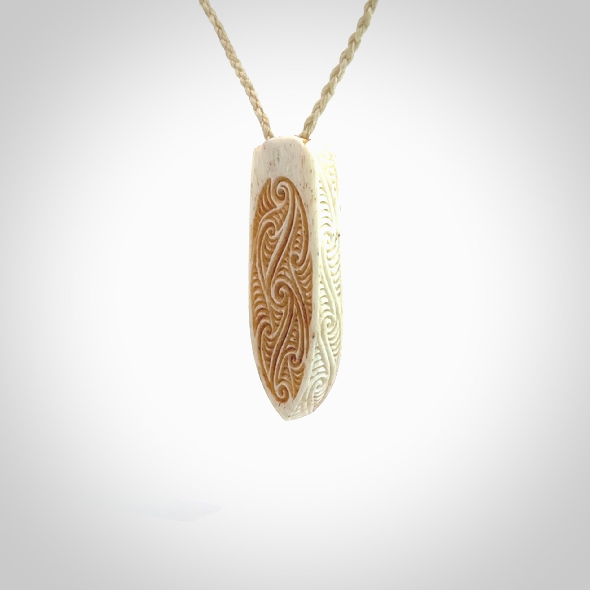 This is a wonderful, finely carved drop pendant. It is hand carved by Andrew Doughty and we will ship it to you free anywhere in the world. Hand made from bone and delivered to you with an adjustable ice white cord.