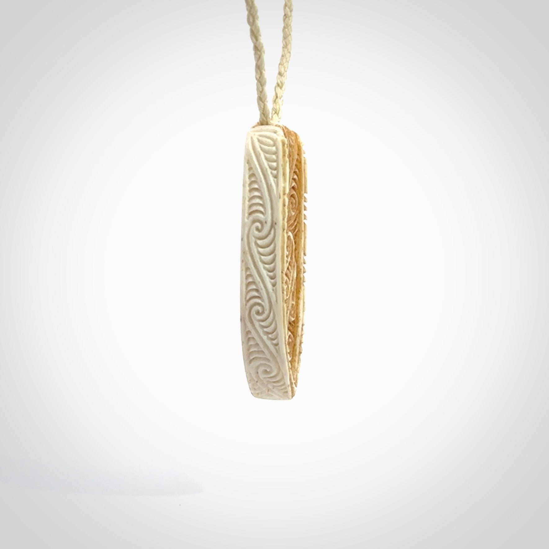 This is a wonderful, finely carved drop pendant. It is hand carved by Andrew Doughty and we will ship it to you free anywhere in the world. Hand made from bone and delivered to you with an adjustable ice white cord.