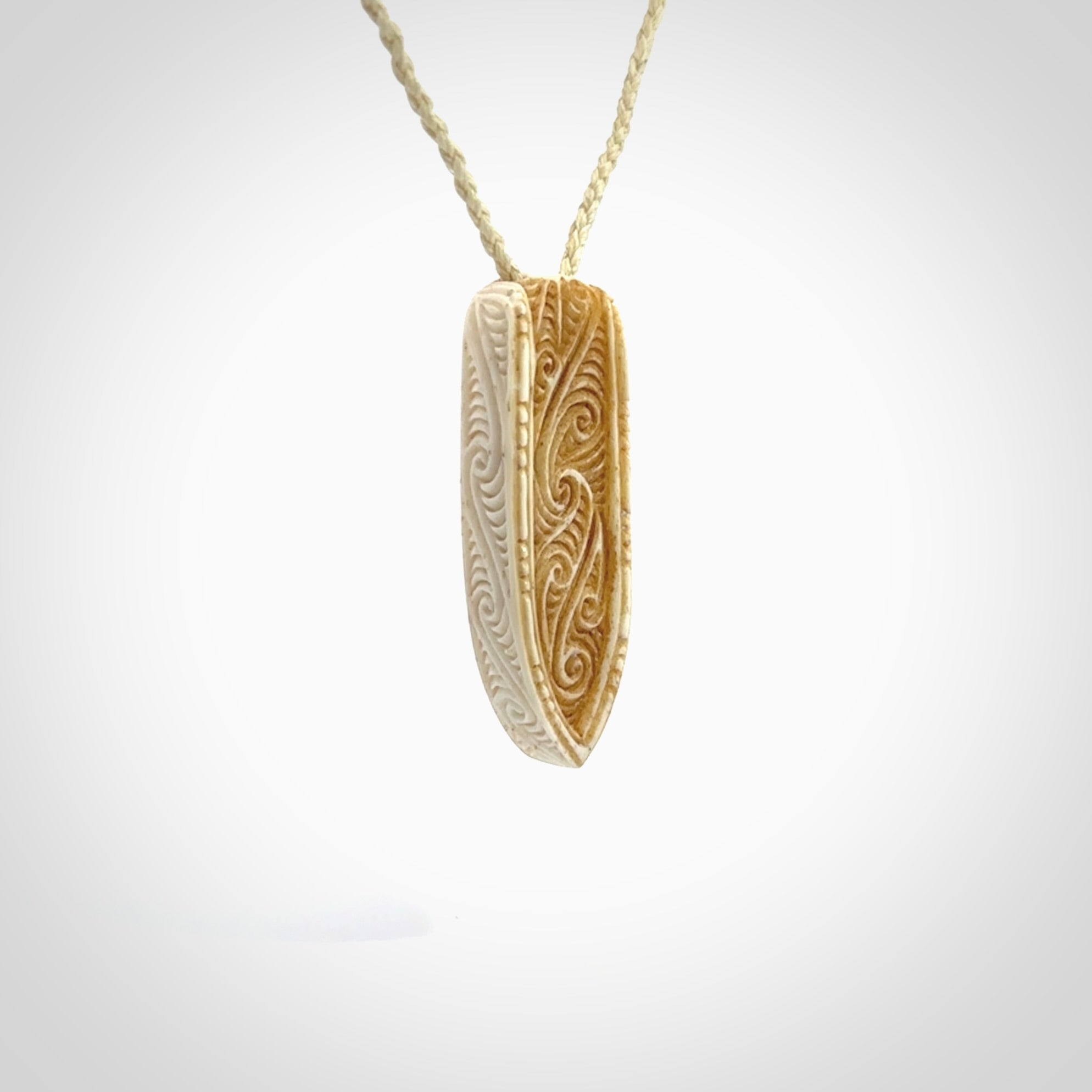 This is a wonderful, finely carved drop pendant. It is hand carved by Andrew Doughty and we will ship it to you free anywhere in the world. Hand made from bone and delivered to you with an adjustable ice white cord.