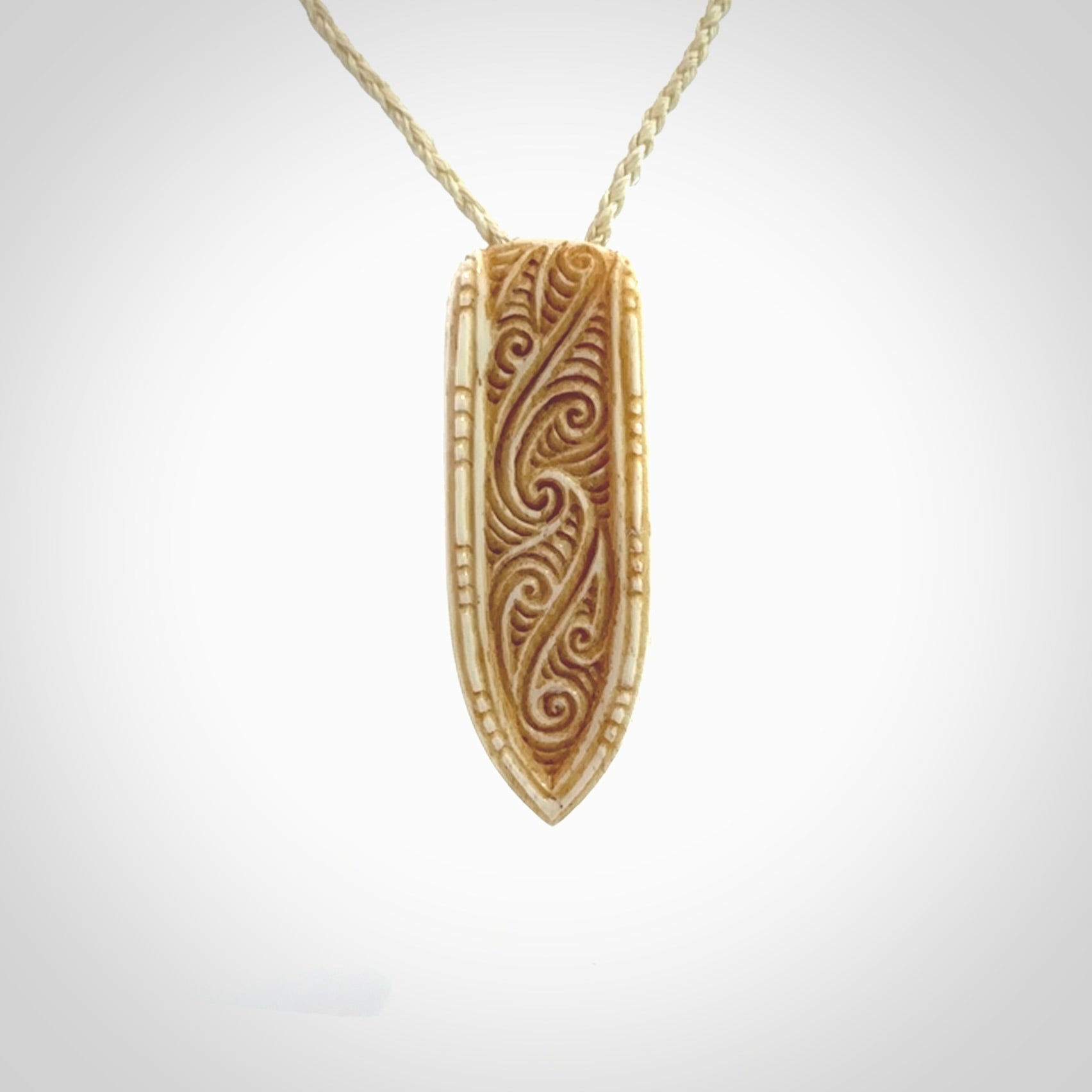 This is a wonderful, finely carved drop pendant. It is hand carved by Andrew Doughty and we will ship it to you free anywhere in the world. Hand made from bone and delivered to you with an adjustable ice white cord.