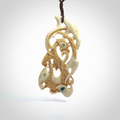 This is a wonderful, finely carved Manaia with Tiki drop pendant. It is hand carved by Andrew Doughty and we will ship it to you free anywhere in the world. Hand made from bone and delivered to you with an adjustable brown cord.