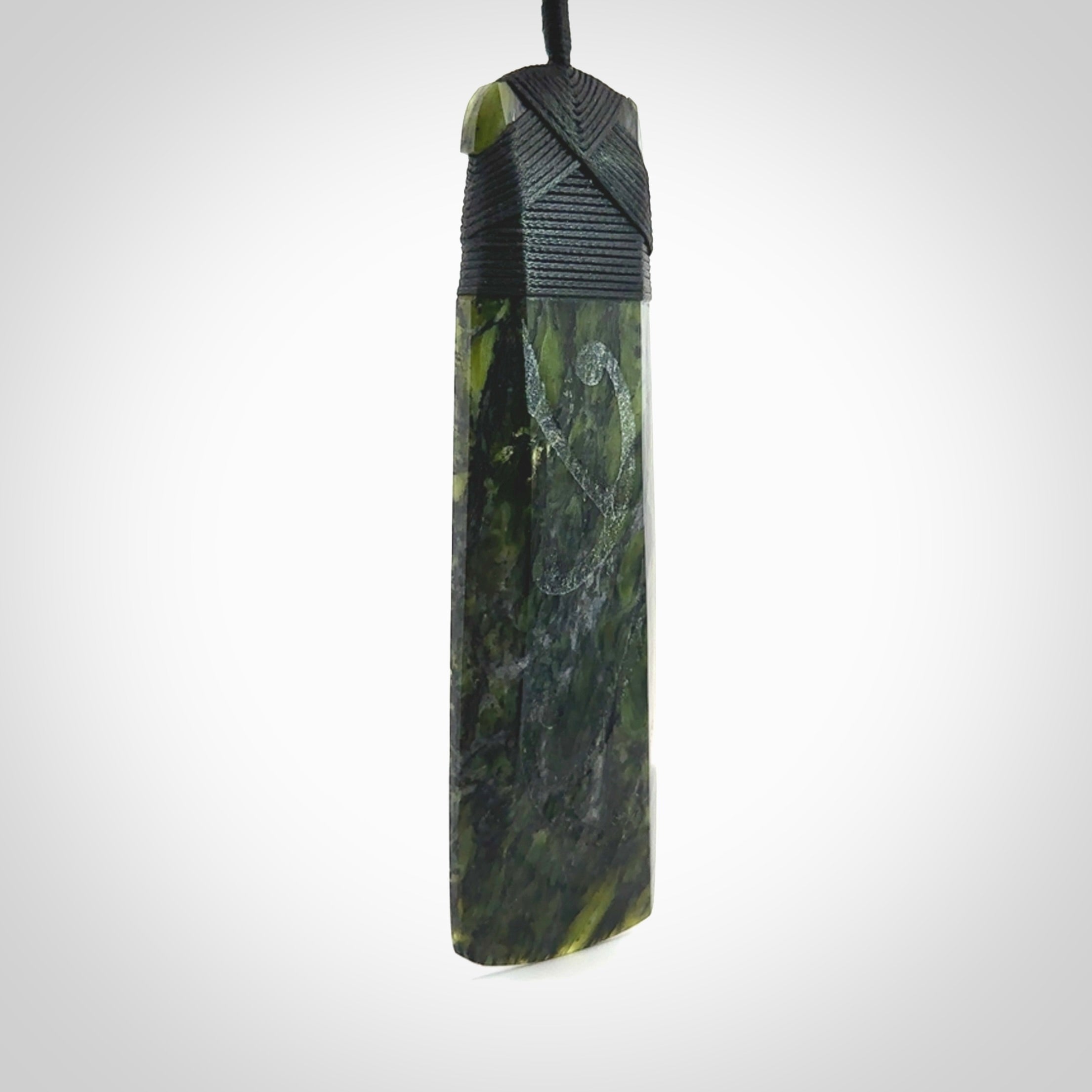 Large Tangiwai Pounamu Toki pendant. Hand carved from a lovely piece of local New Zealand Tangiwai. The quality of the workmanship and design is outstanding - this is a piece you will want to wear all the time. We have suspended this from an adjustable 3-plait black cord and binding.