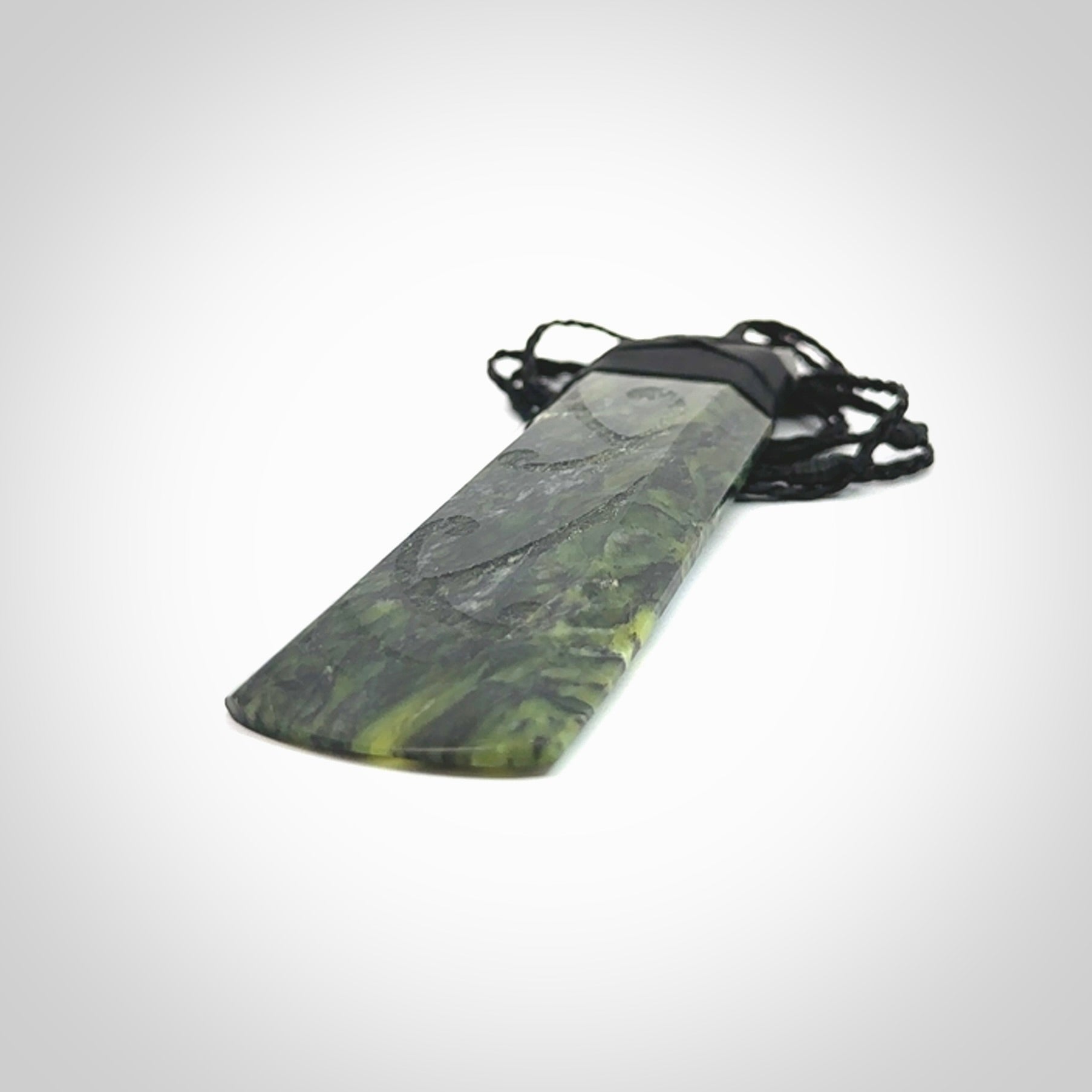 Large Tangiwai Pounamu Toki pendant. Hand carved from a lovely piece of local New Zealand Tangiwai. The quality of the workmanship and design is outstanding - this is a piece you will want to wear all the time. We have suspended this from an adjustable 3-plait black cord and binding.