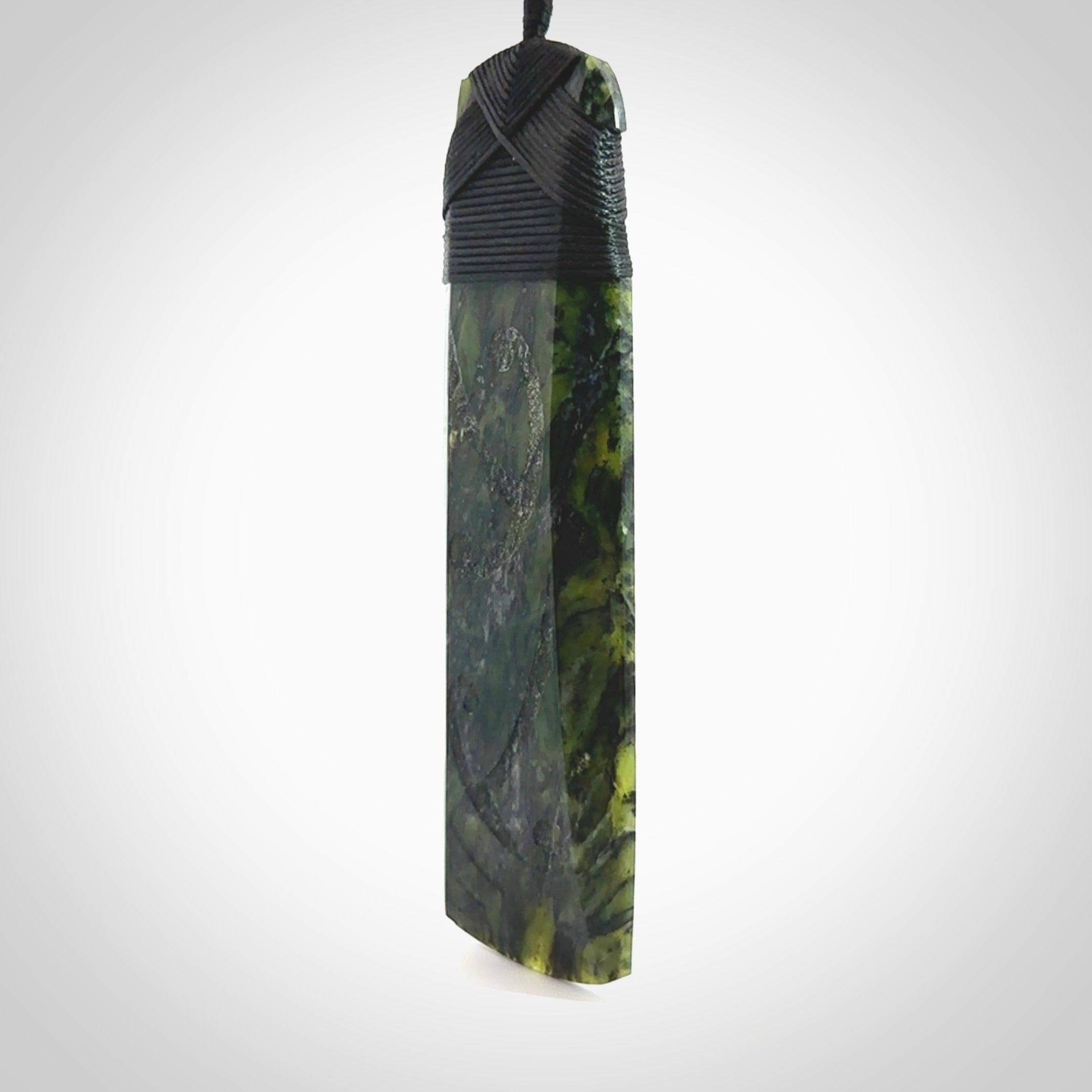 Large Tangiwai Pounamu Toki pendant. Hand carved from a lovely piece of local New Zealand Tangiwai. The quality of the workmanship and design is outstanding - this is a piece you will want to wear all the time. We have suspended this from an adjustable 3-plait black cord and binding.