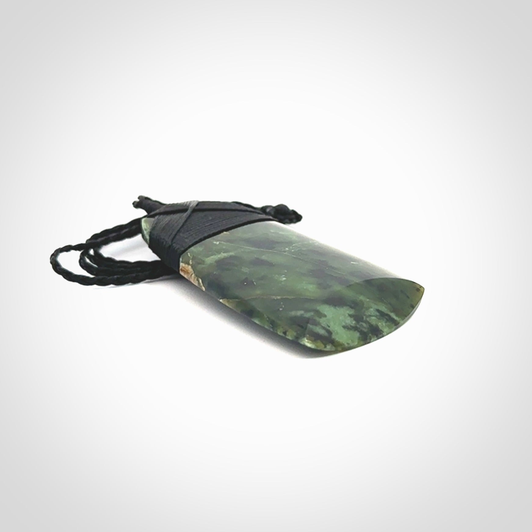 Hand carved from a lovely piece of local New Zealand Tangiwai Pounamu. The quality of the workmanship and design is outstanding - this is a piece you will want to wear all the time. We have suspended this Toki from an adjustable 3-plait black cord and binding.