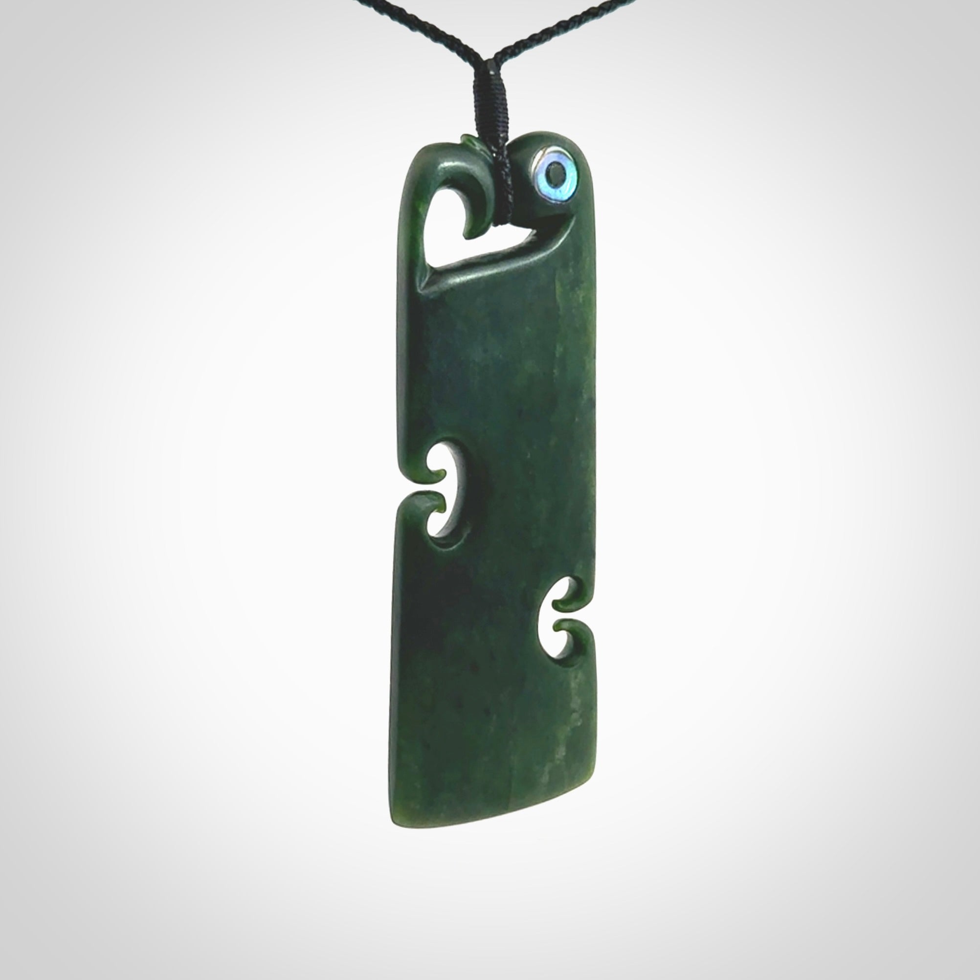 This is a beautiful large New Zealand Jade, pounamu Manaia Toki pendant with double Koru and Paua Shell eyes. Hand carved for us by Kyohei Noguchi. It is bound with an adjustable black coloured cord which is length adjustable. Free worldwide shipping. We have one only.