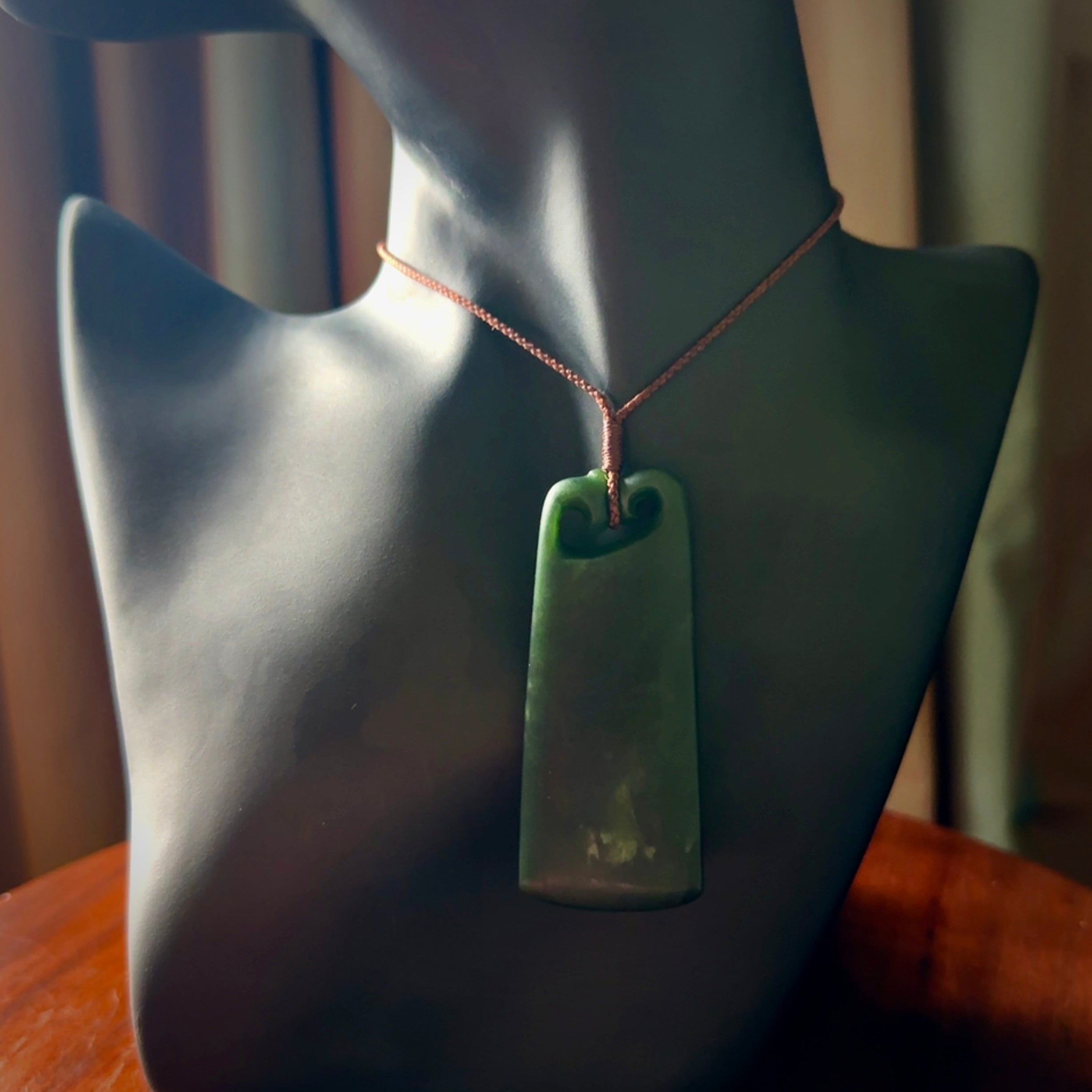 This is a lovely New Zealand Jade, pounamu drop pendant. Hand carved for us by Kyohei Noguchi. It is bound with an adjustable brown coloured cord which is length adjustable. Free worldwide shipping.