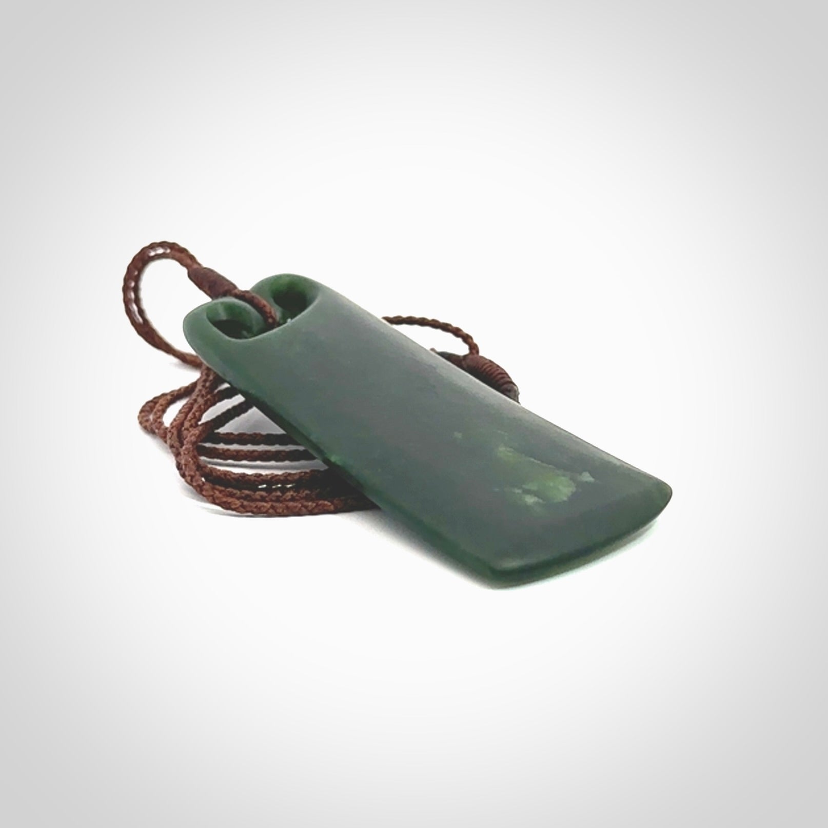 This is a lovely New Zealand Jade, pounamu drop pendant. Hand carved for us by Kyohei Noguchi. It is bound with an adjustable brown coloured cord which is length adjustable. Free worldwide shipping.