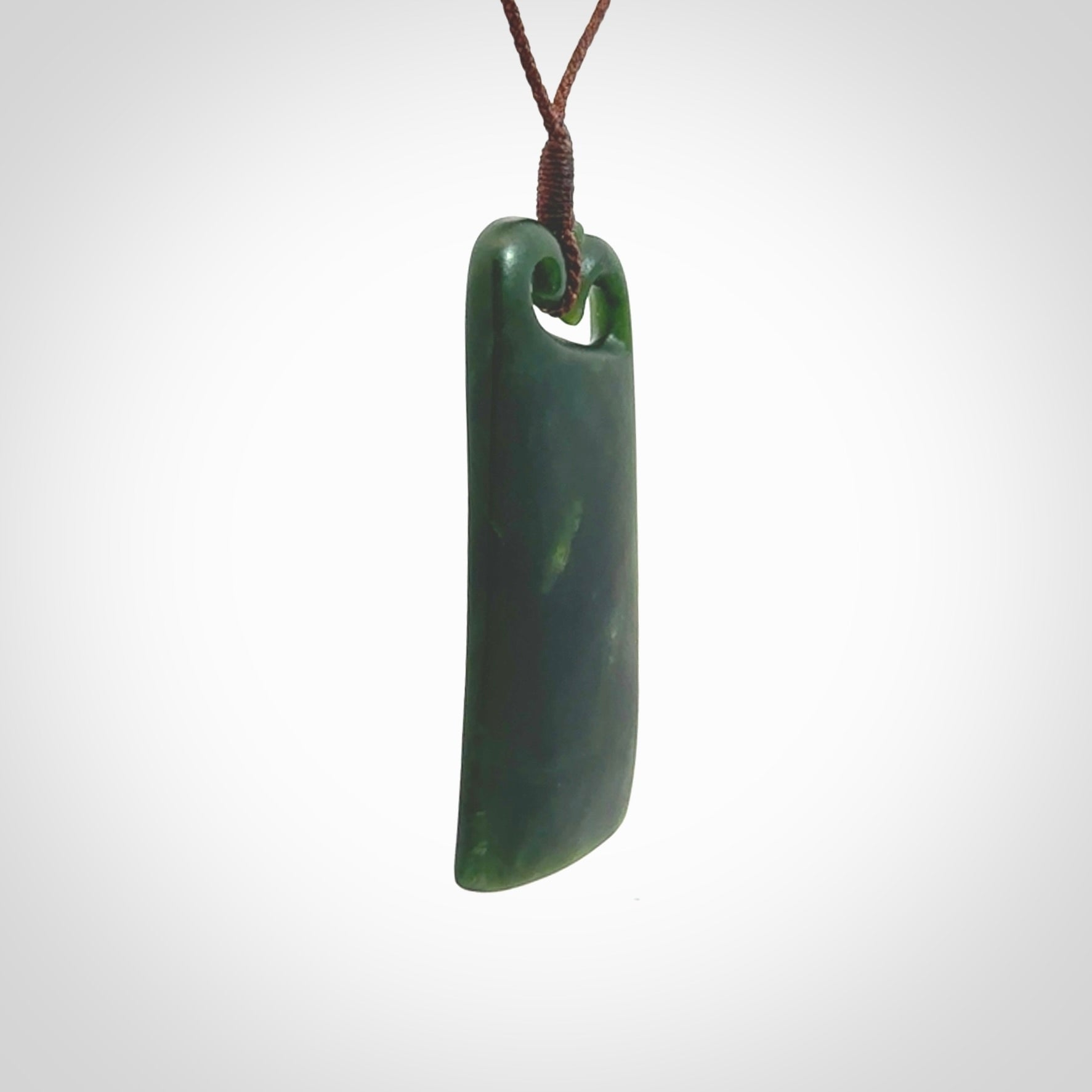 This is a lovely New Zealand Jade, pounamu drop pendant. Hand carved for us by Kyohei Noguchi. It is bound with an adjustable brown coloured cord which is length adjustable. Free worldwide shipping.