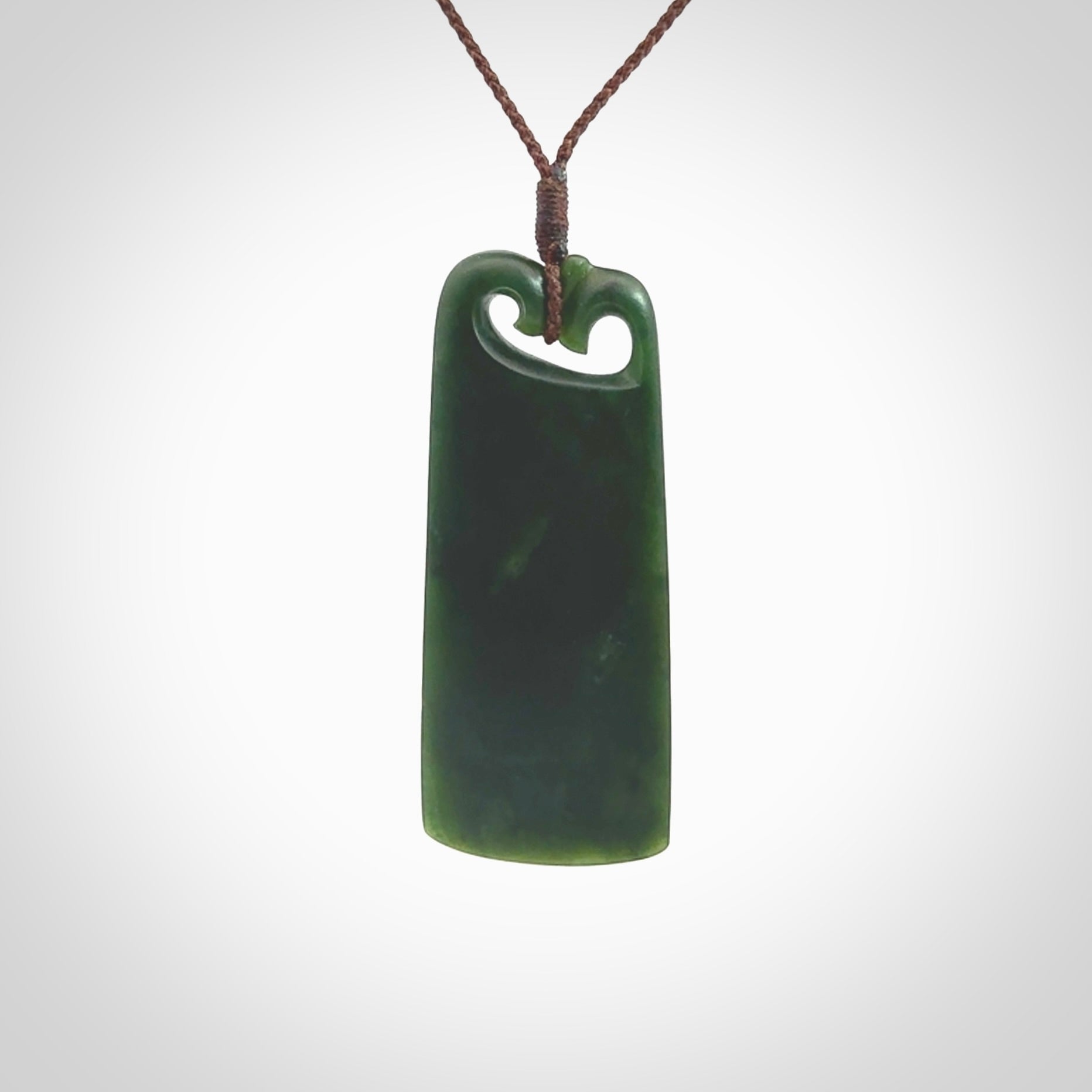 This is a lovely New Zealand Jade, pounamu drop pendant. Hand carved for us by Kyohei Noguchi. It is bound with an adjustable brown coloured cord which is length adjustable. Free worldwide shipping.