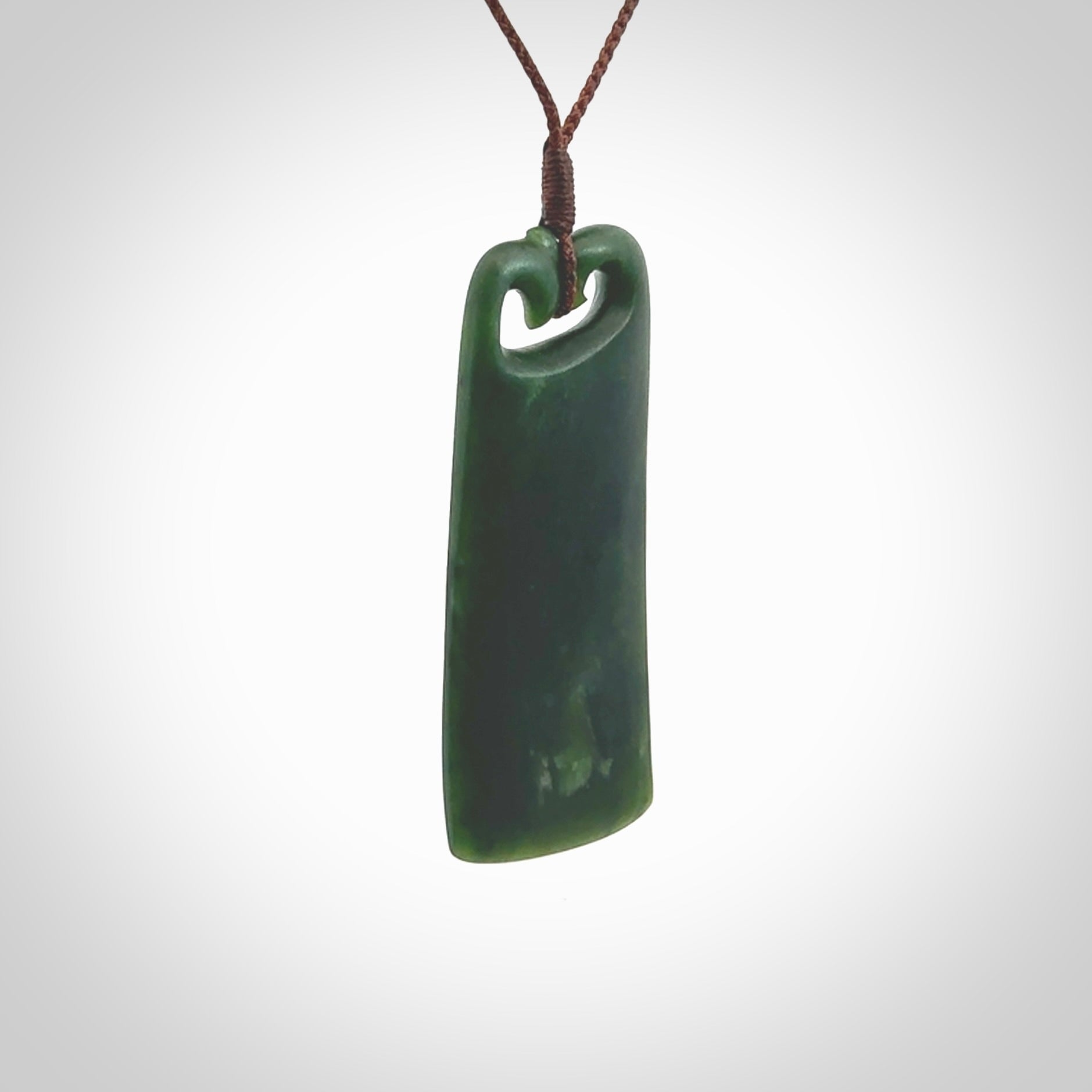 This is a lovely New Zealand Jade, pounamu drop pendant. Hand carved for us by Kyohei Noguchi. It is bound with an adjustable brown coloured cord which is length adjustable. Free worldwide shipping.