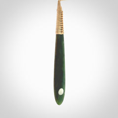 This photo shows a large beautiful jade drop with whale tooth inlay. It is hand carved from a piece of green New Zealand pounamu, with fascinating light green inclusions throughout the stone. We have this on a beige coloured, adjustable four plait cord. We ship this worldwide with an express courier service. Postage is free.