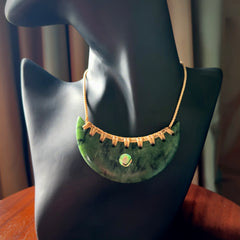 This picture shows a large hand carved jade contemporary half-shield pendant with Paua Shell inlay. It is a deep green and is a wonderful, delicate piece of jewellery. The cord is hand plaited and adjustable so that you can position the pendant where it suits you best. This piece was carved for us by Kyohei Noguchi. Delivery is free worldwide.