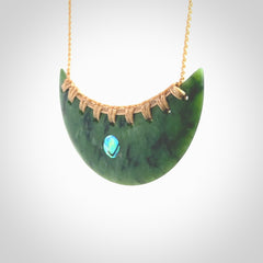 This picture shows a large hand carved jade contemporary half-shield pendant with Paua Shell inlay. It is a deep green and is a wonderful, delicate piece of jewellery. The cord is hand plaited and adjustable so that you can position the pendant where it suits you best. This piece was carved for us by Kyohei Noguchi. Delivery is free worldwide.