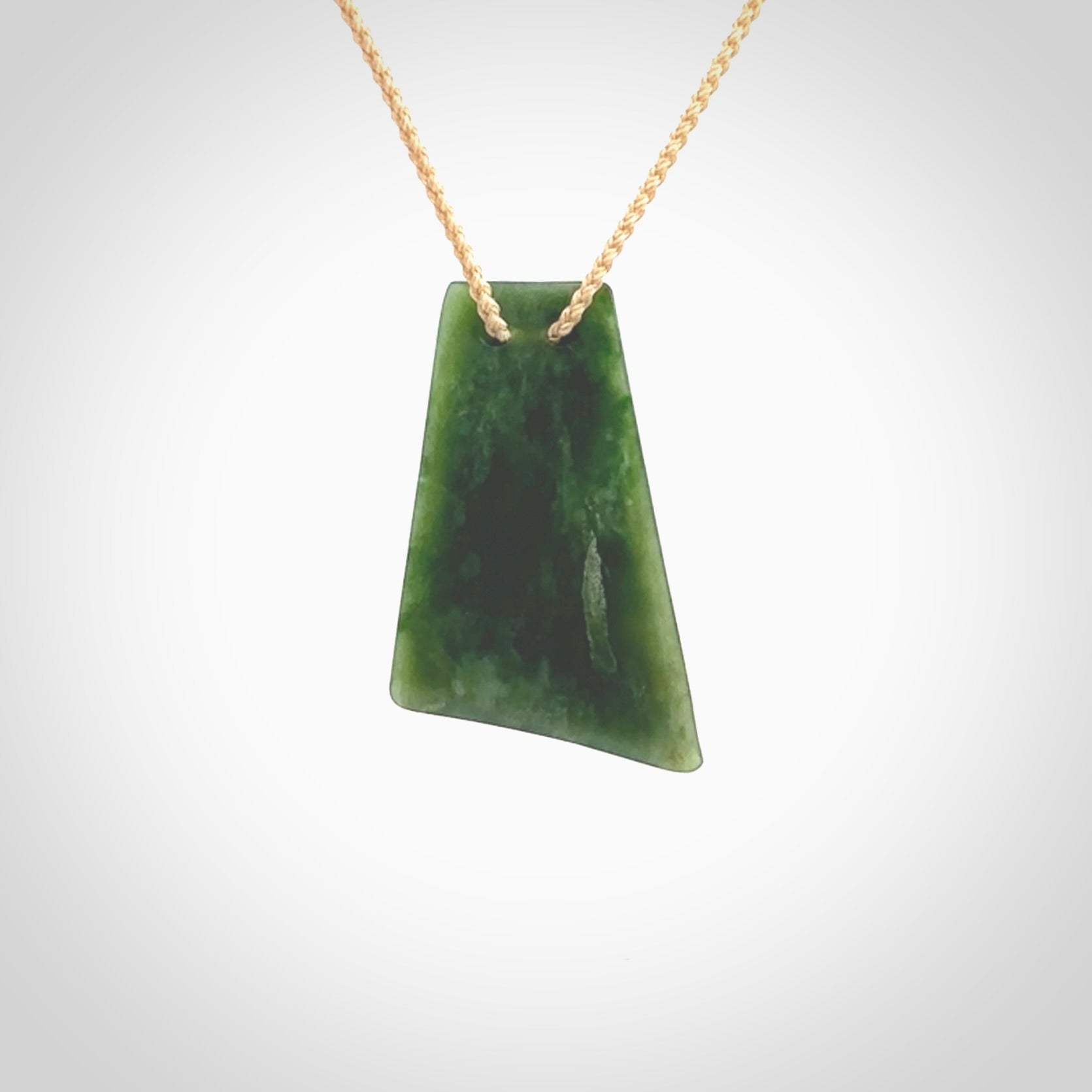 This is a lovely New Zealand Jade, pounamu drop pendant. Hand carved for us by Ric Moor. It is bound with an adjustable beige coloured cord which is length adjustable. Free worldwide shipping. The light reveals the internal structure and colour of the stone beautifully.