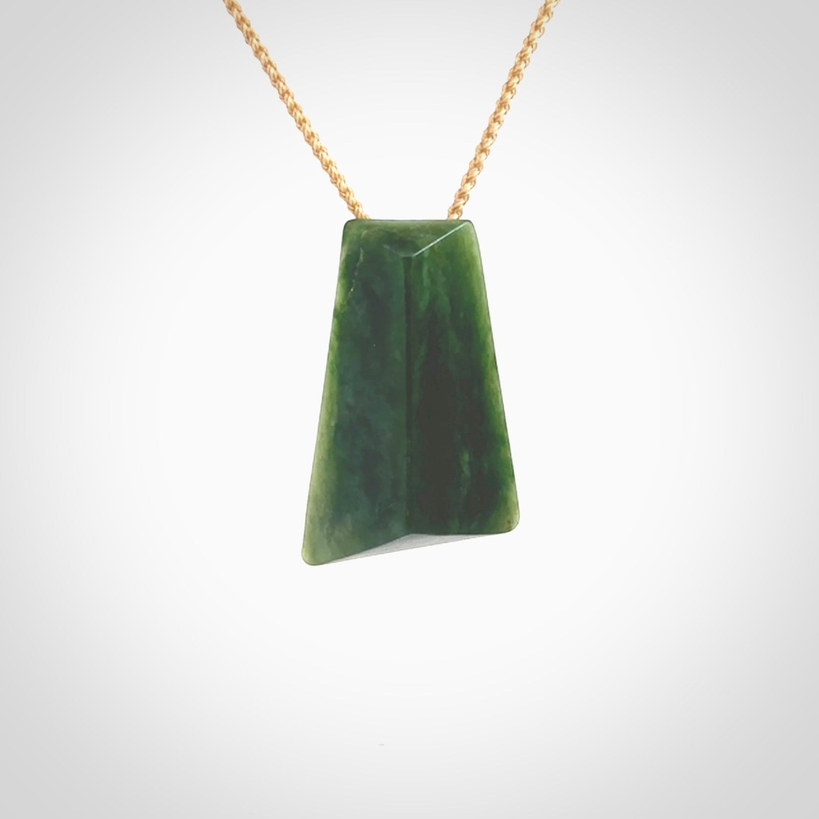 This is a lovely New Zealand Jade, pounamu drop pendant. Hand carved for us by Ric Moor. It is bound with an adjustable beige coloured cord which is length adjustable. Free worldwide shipping. The light reveals the internal structure and colour of the stone beautifully.