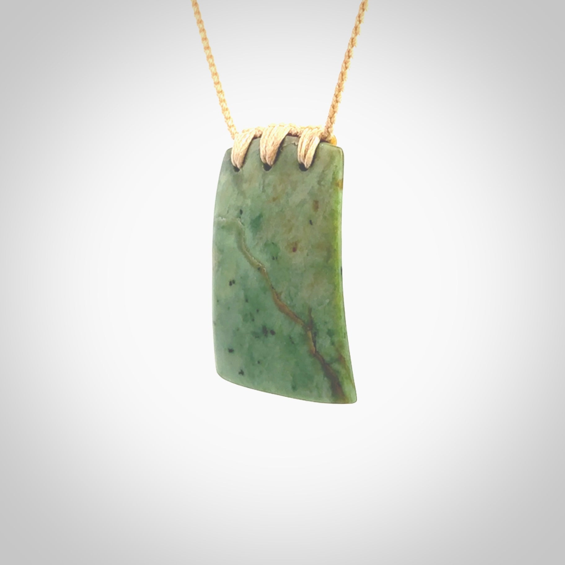 This is a lovely New Zealand Jade, pounamu drop pendant. Hand carved for us by Ric Moor. It is bound with an adjustable beige coloured cord which is length adjustable. Free worldwide shipping.