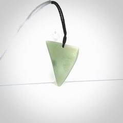 This picture shows a hand carved jade drop pendant by Ric Moor. The jade is a wonderful light, semi-translucent, green. It is suspended from a black adjustable cord. Delivery is free worldwide.