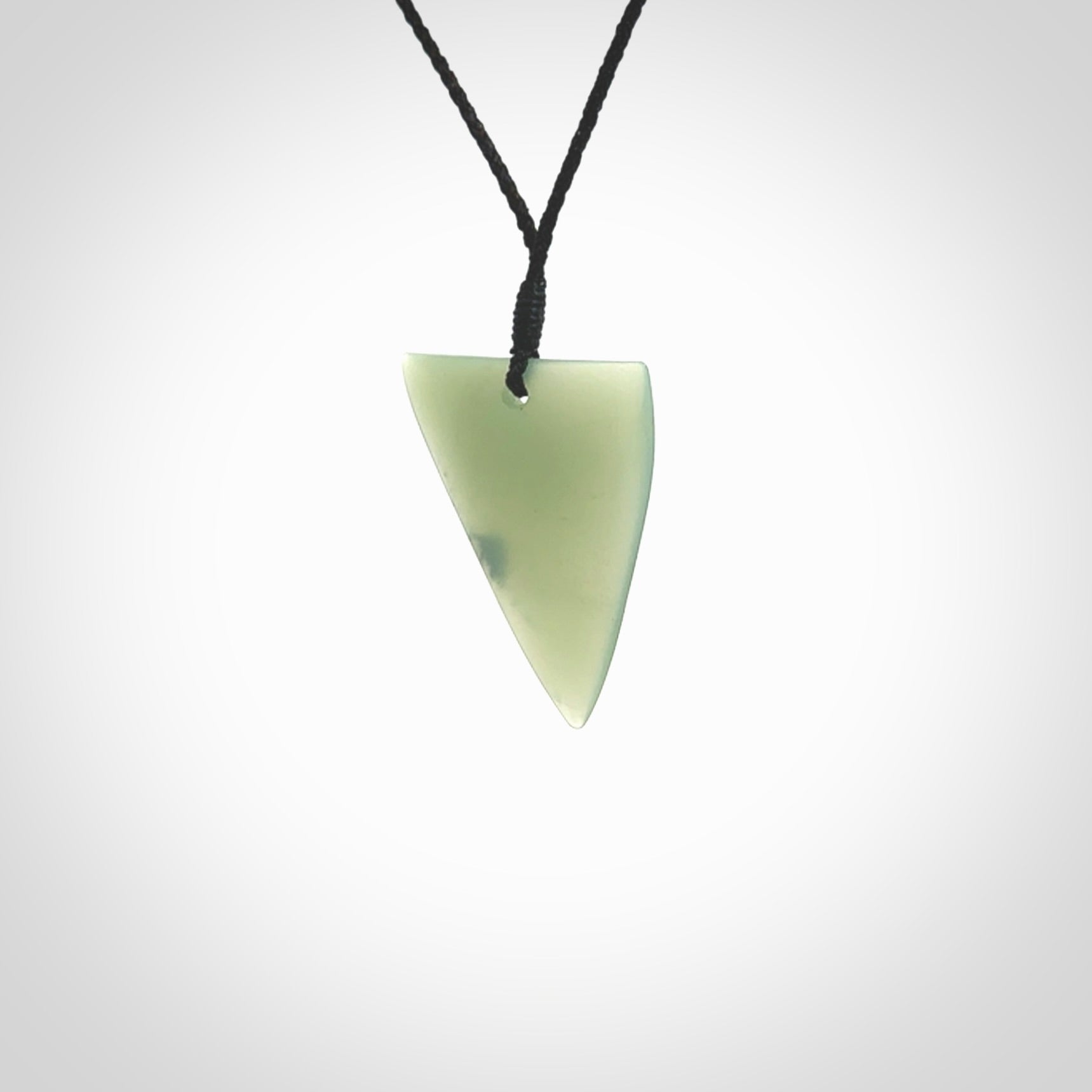 This picture shows a hand carved jade drop pendant by Ric Moor. The jade is a wonderful light, semi-translucent, green. It is suspended from a black adjustable cord. Delivery is free worldwide.