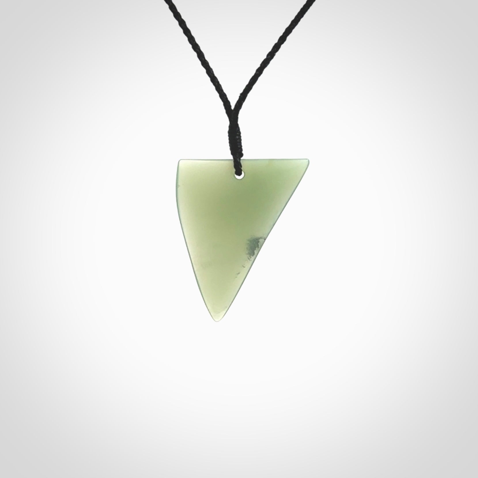 This picture shows a hand carved jade drop pendant by Ric Moor. The jade is a wonderful light, semi-translucent, green. It is suspended from a black adjustable cord. Delivery is free worldwide.