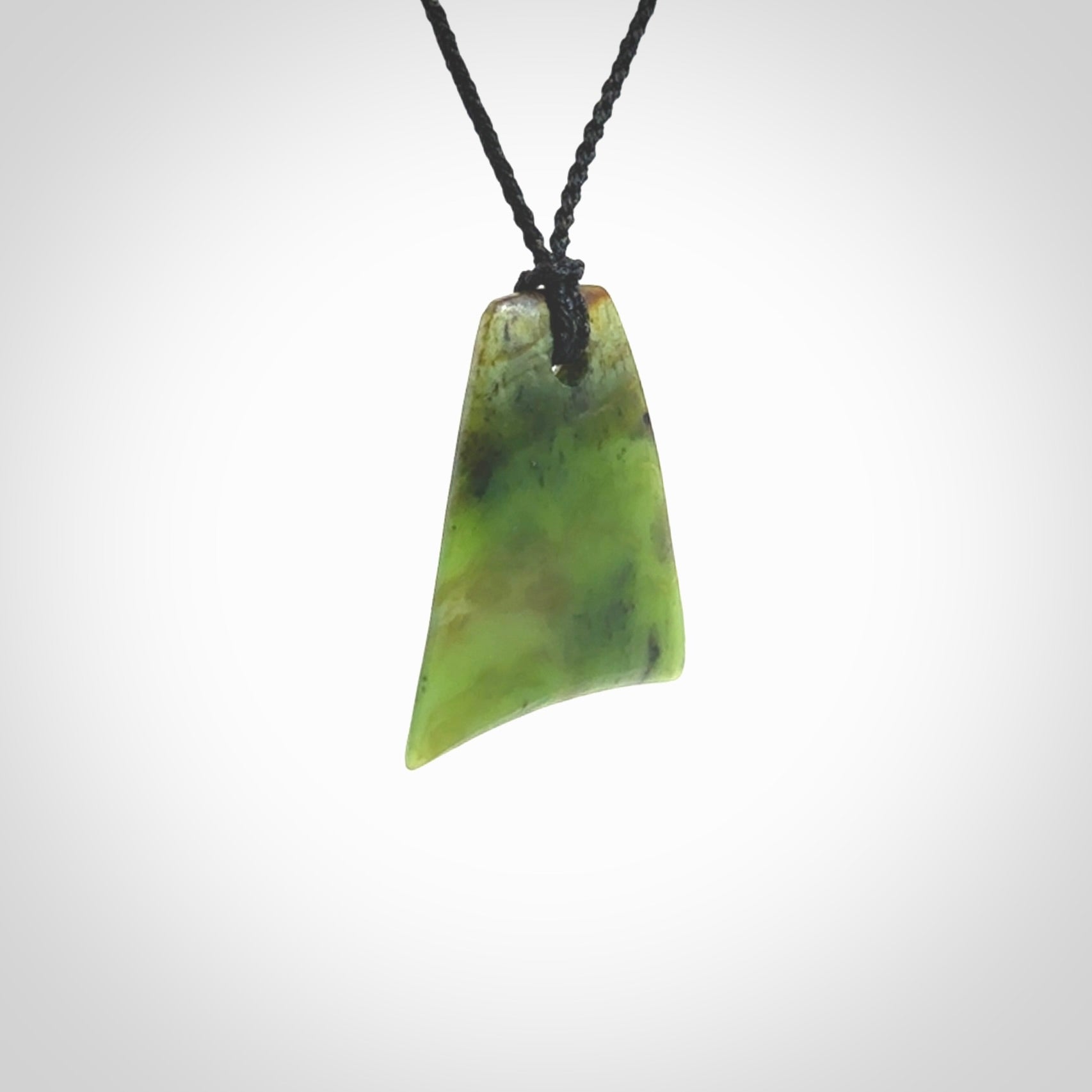 This is a lovely New Zealand Jade, pounamu drop pendant. Hand carved for us by Ric Moor. It is bound with an adjustable black coloured cord which is length adjustable. Free worldwide shipping.