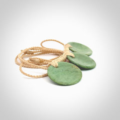 This piece is a triple disc pendant. It was carved for us by Ric Moor from a lovely light and milky green piece of New Zealand jade. It is suspended on a beige coloured braided cord that is length adjustable. One only.