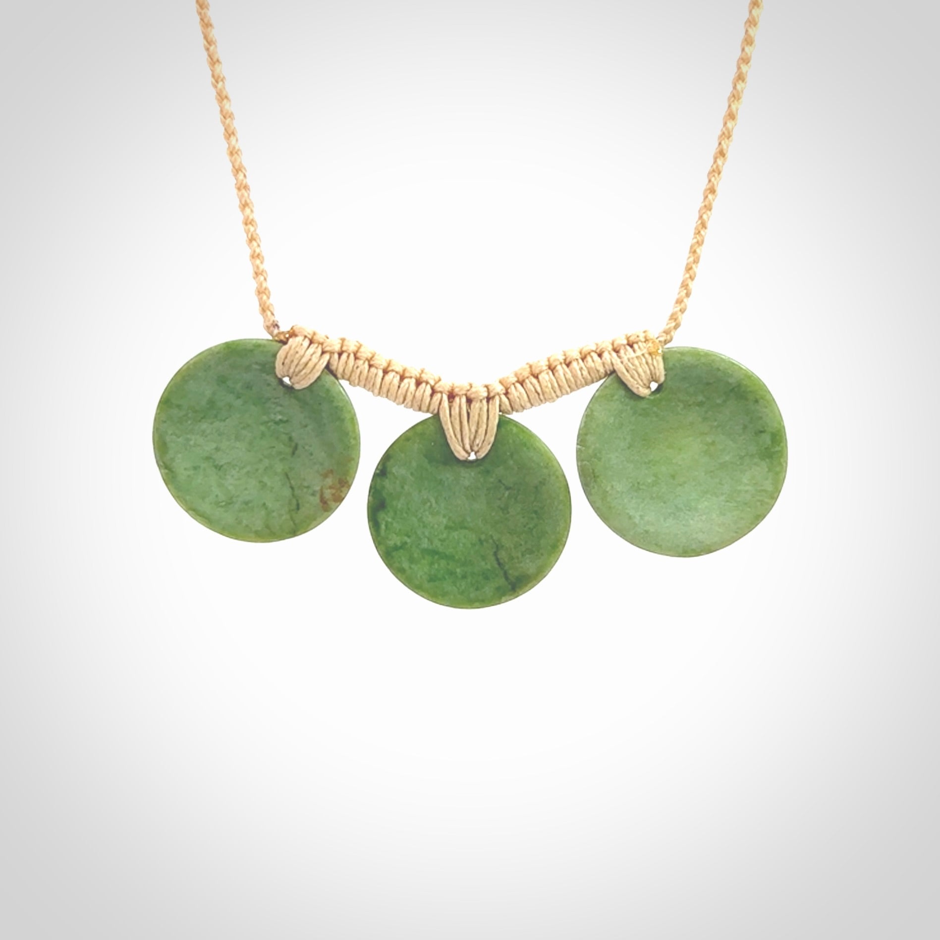 This piece is a triple disc pendant. It was carved for us by Ric Moor from a lovely light and milky green piece of New Zealand jade. It is suspended on a beige coloured braided cord that is length adjustable. One only.