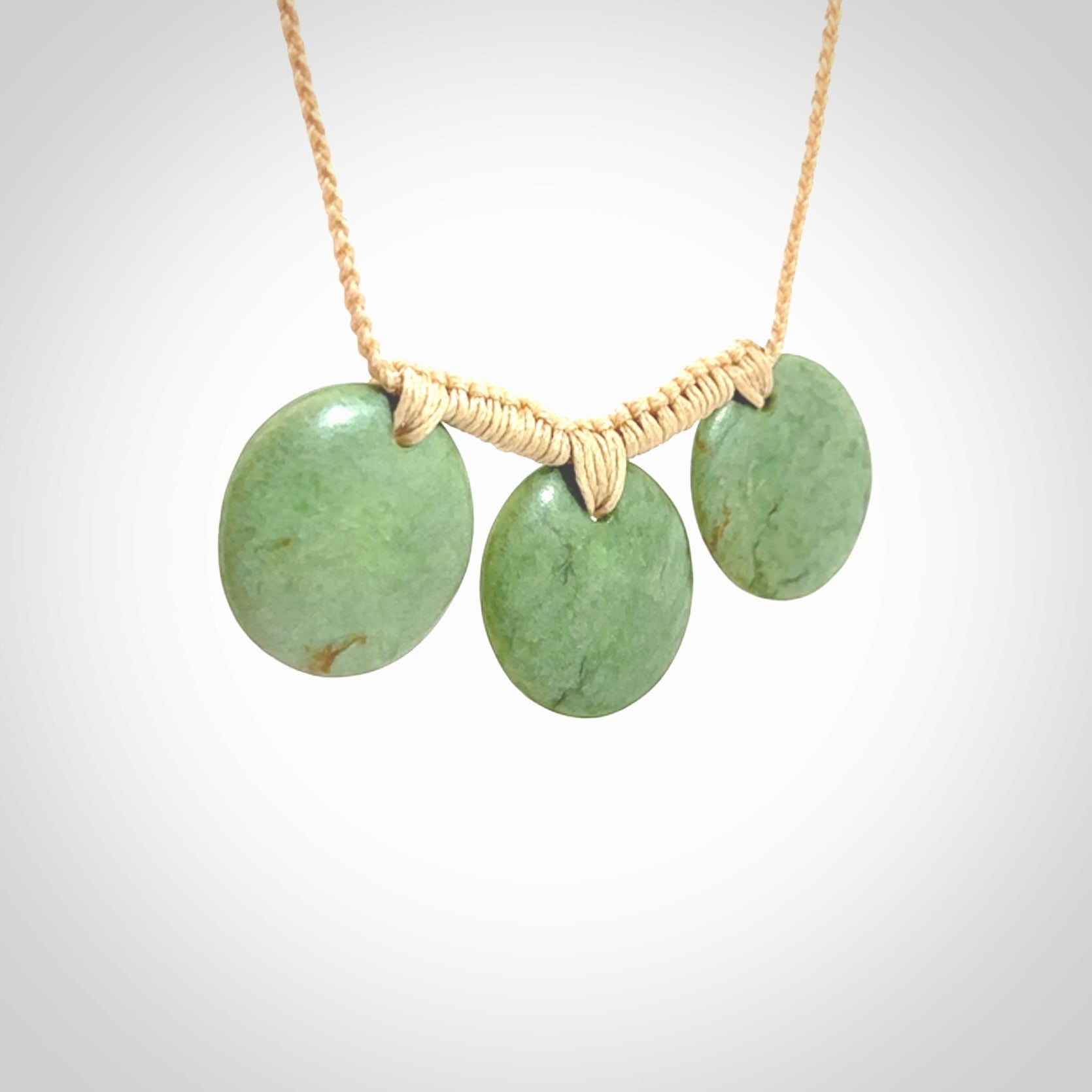 This piece is a triple disc pendant. It was carved for us by Ric Moor from a lovely light and milky green piece of New Zealand jade. It is suspended on a beige coloured braided cord that is length adjustable. One only.