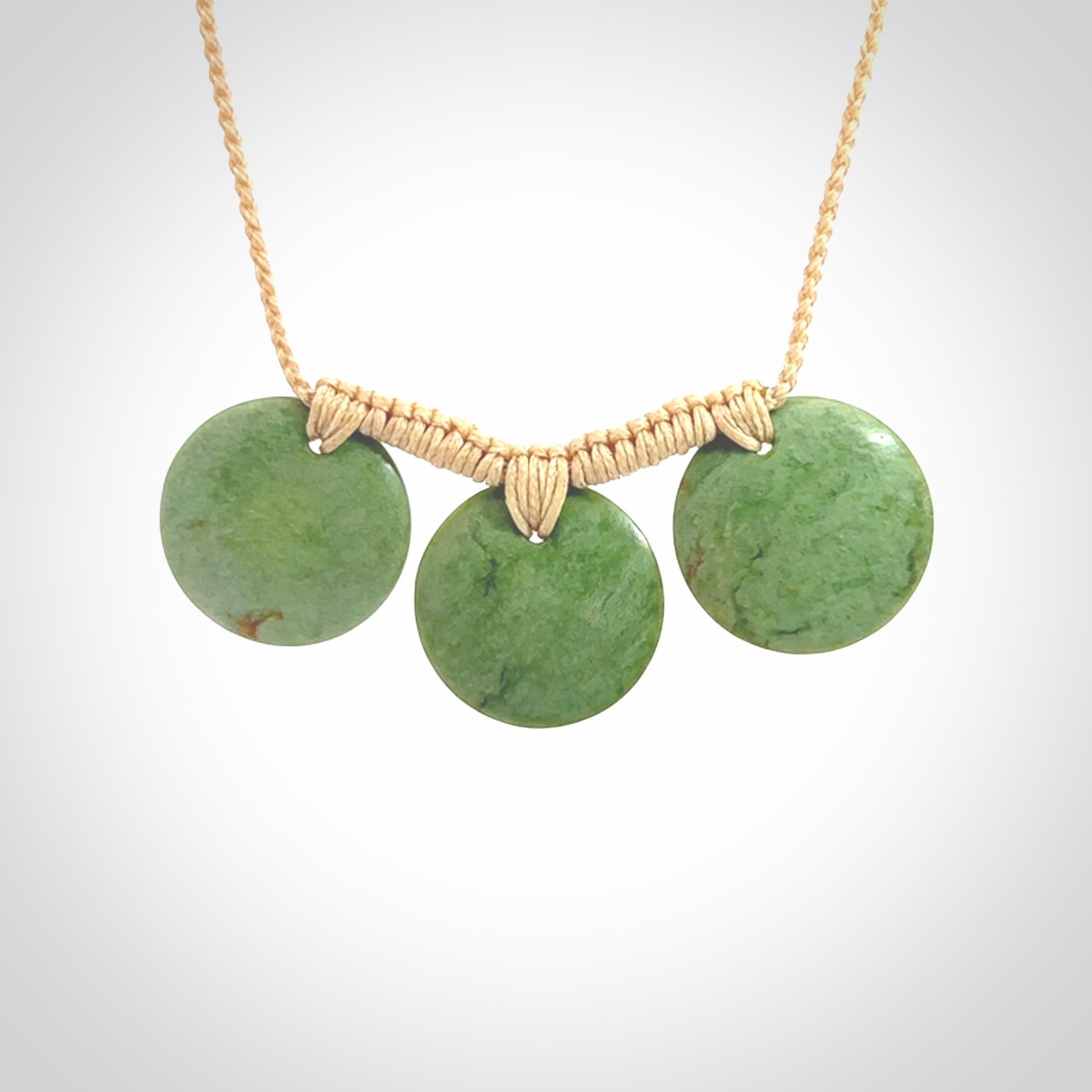 This piece is a triple disc pendant. It was carved for us by Ric Moor from a lovely light and milky green piece of New Zealand jade. It is suspended on a beige coloured braided cord that is length adjustable. One only.