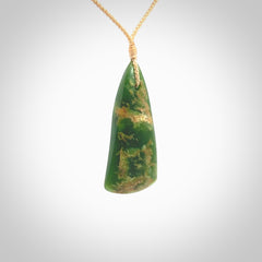 This photo shows a large jade drop shaped pendant. It a a lovely green and orange jade. The cord is a four plait beige and is adjustable in length. One only large, contemporary drop necklace from Jade, by Ric Moor.