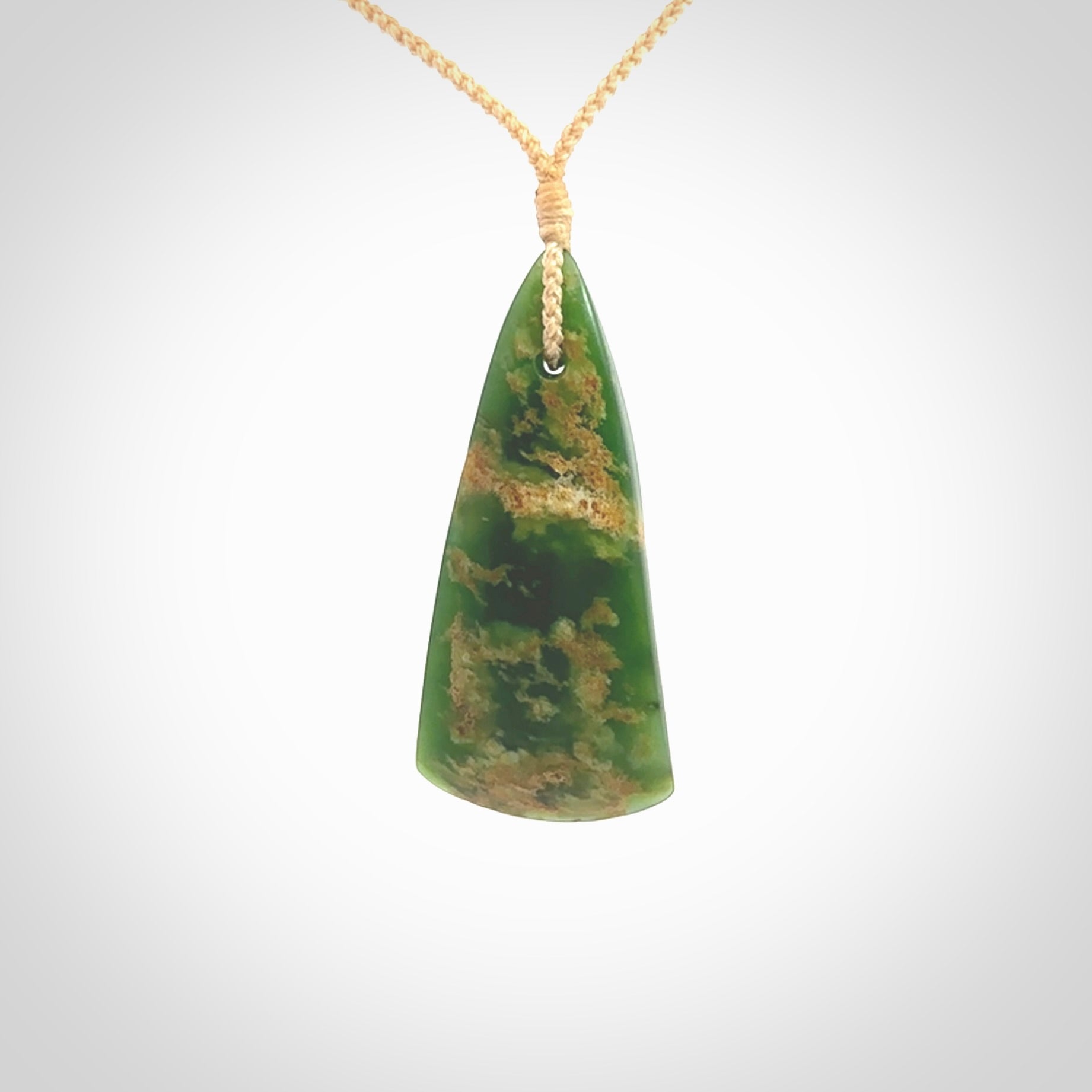 This photo shows a large jade drop shaped pendant. It a a lovely green and orange jade. The cord is a four plait beige and is adjustable in length. One only large, contemporary drop necklace from Jade, by Ric Moor.