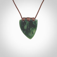 This photo shows a jade drop shaped pendant. It a a lovely deep green jade. The cord is a four plait brown and is adjustable in length. One only medium, contemporary drop necklace from Jade, by Ric Moor.