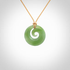 This is a small light green New Zealand jade koru pendant. We have bound this with a fine beige coloured cord necklace. The necklace is adjustable so you can position the piece where it suits you the best.