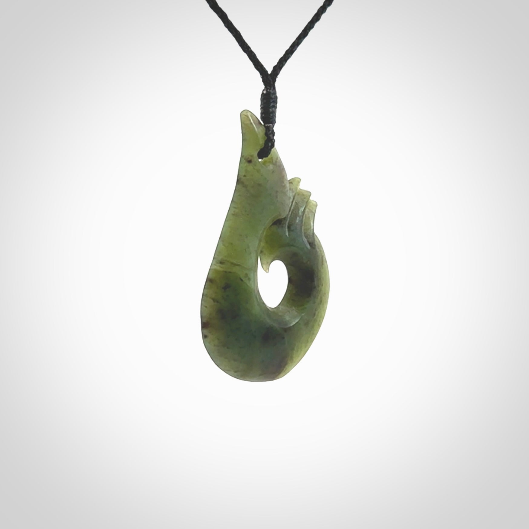 This hook, is carved from a very striking New Zealand jade. It is both intricate and simple in design - it has hidden folds and smooth curves. A piece to be worn or displayed - the carving and the jade are both magnificent.