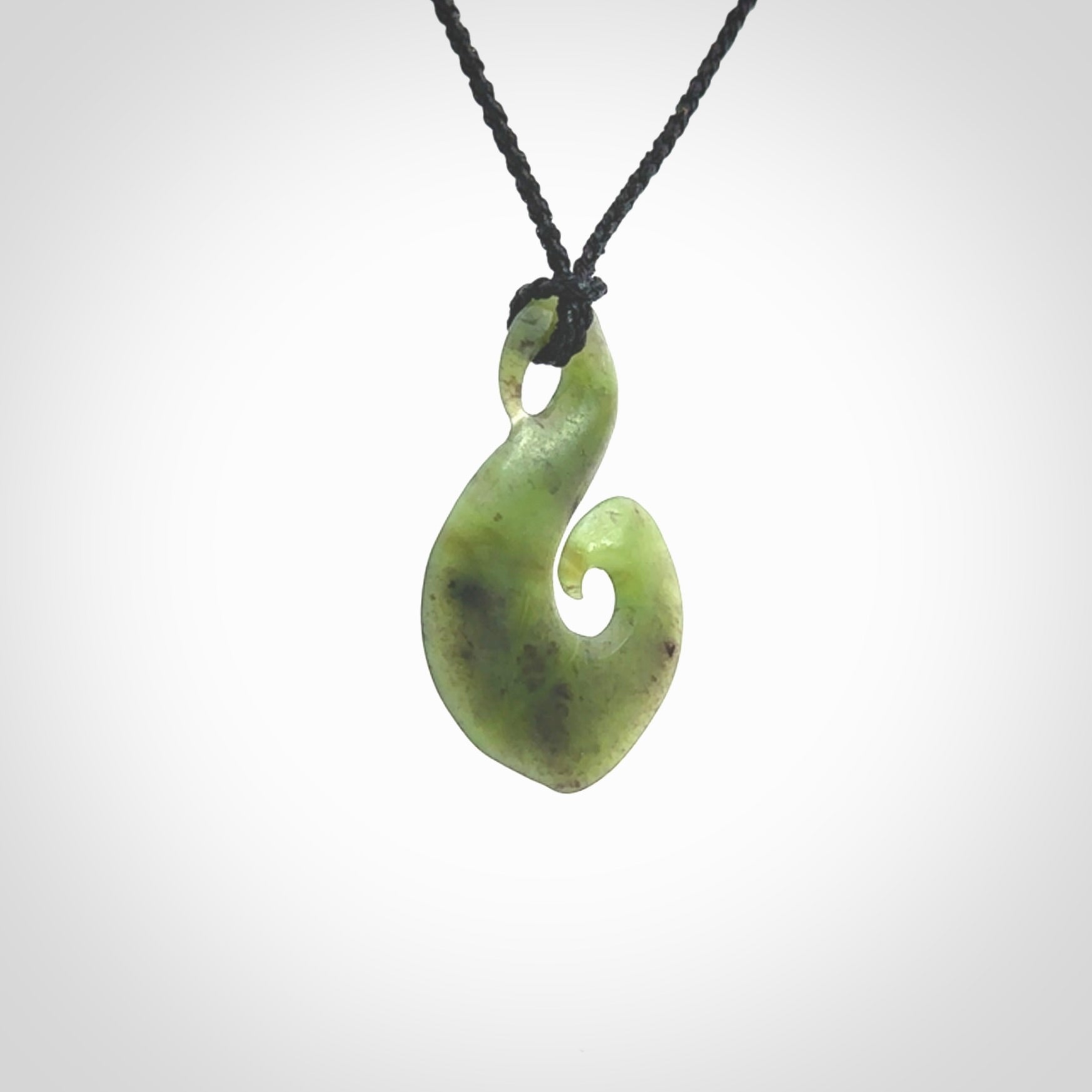 This koru/matau, is carved from a very striking New Zealand jade. It is both intricate and simple in design - it has hidden folds and smooth curves. A piece to be worn, the carving and the jade are both magnificent.